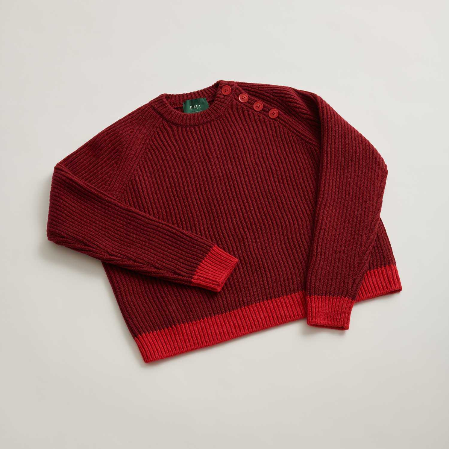 Sweter damski oversize Phi w kolorze czerwonym, z wyraźnym prążkowanym wzorem i kontrastującym dołem.