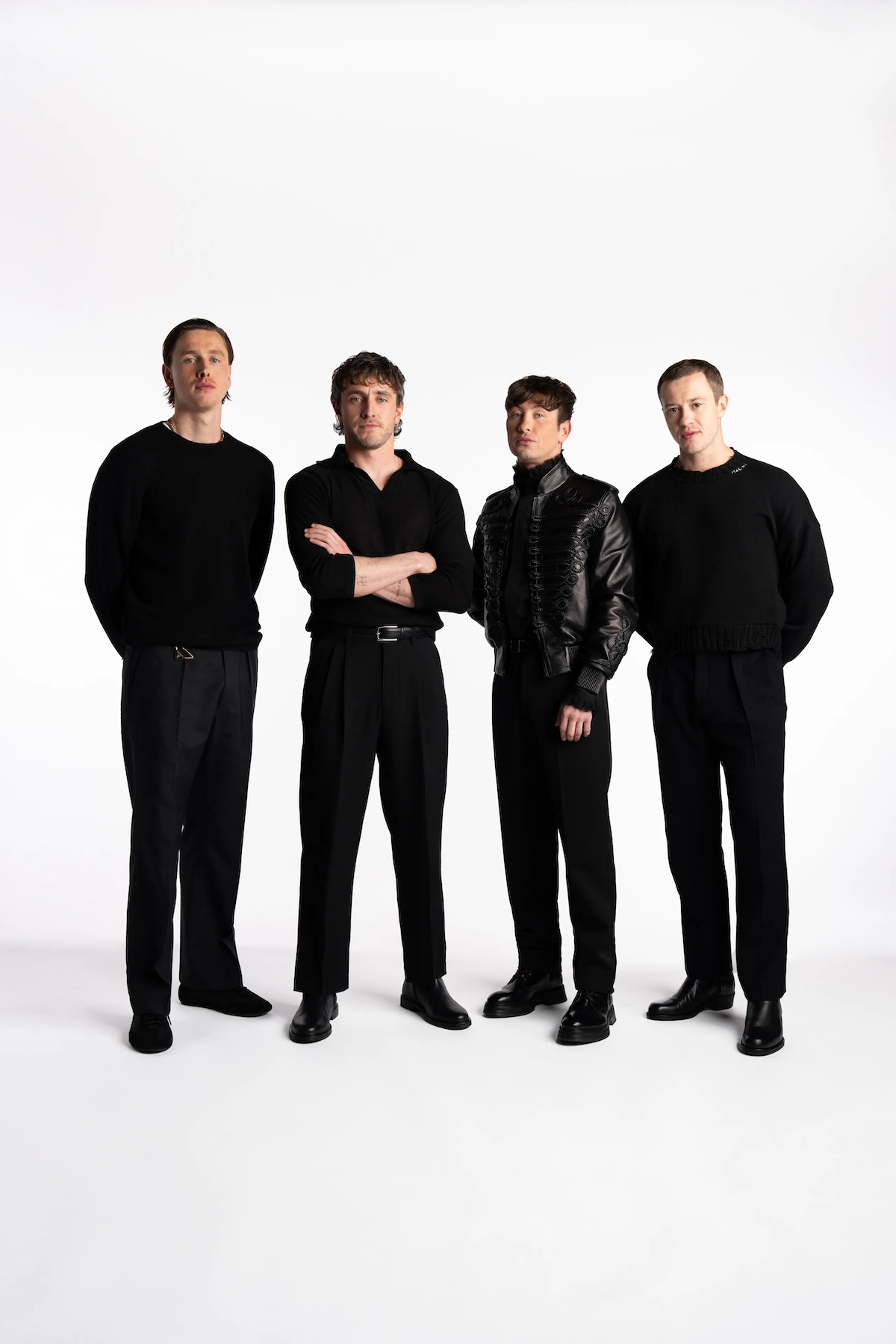 Harris Dickinson, Paul Mescal, Barry Keoghan i Joseph Quinn w eleganckich, czarnych strojach na białym tle.
