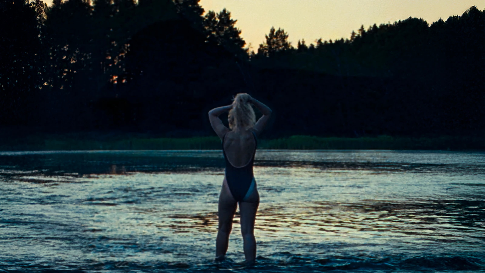 Imogen Poots w filmie "The Chronology of Water" w reżyserii Kristen Stewart, stoi w wodzie o zmierzchu.