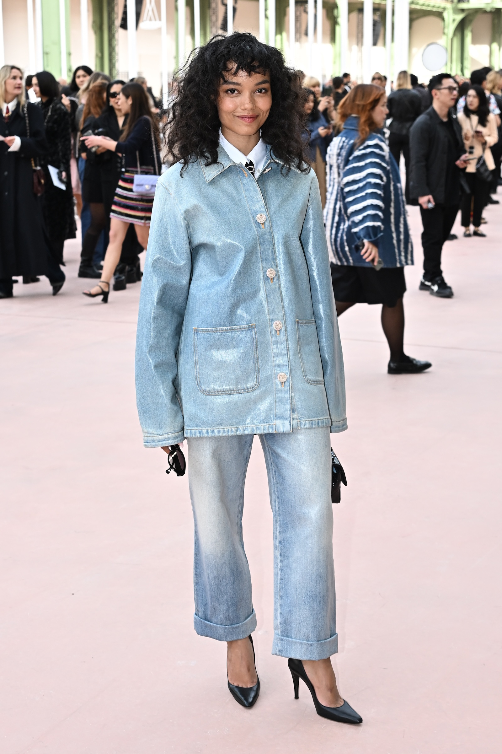 Whitney Peak w błękitnej koszuli jeansowej damskiej i niebieskich spodniach jeansowych na pokazie Chanel.