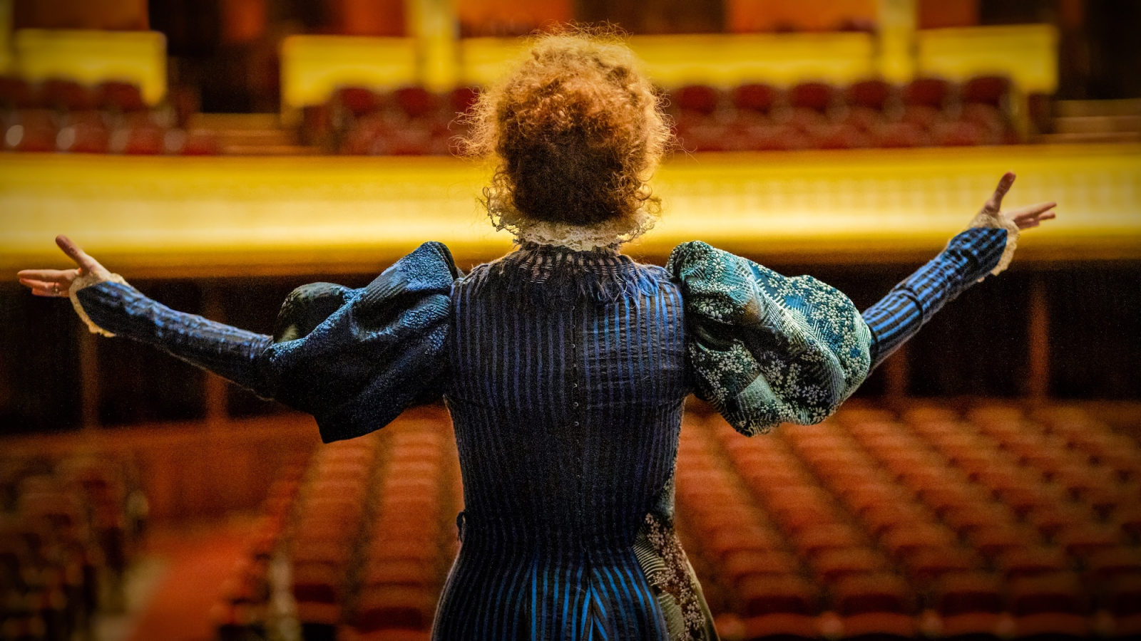 Sandrine Kiberlain jako Sarah Bernhardt w filmie „Boska Sarah Bernhardt” na scenie z widownią w tle.