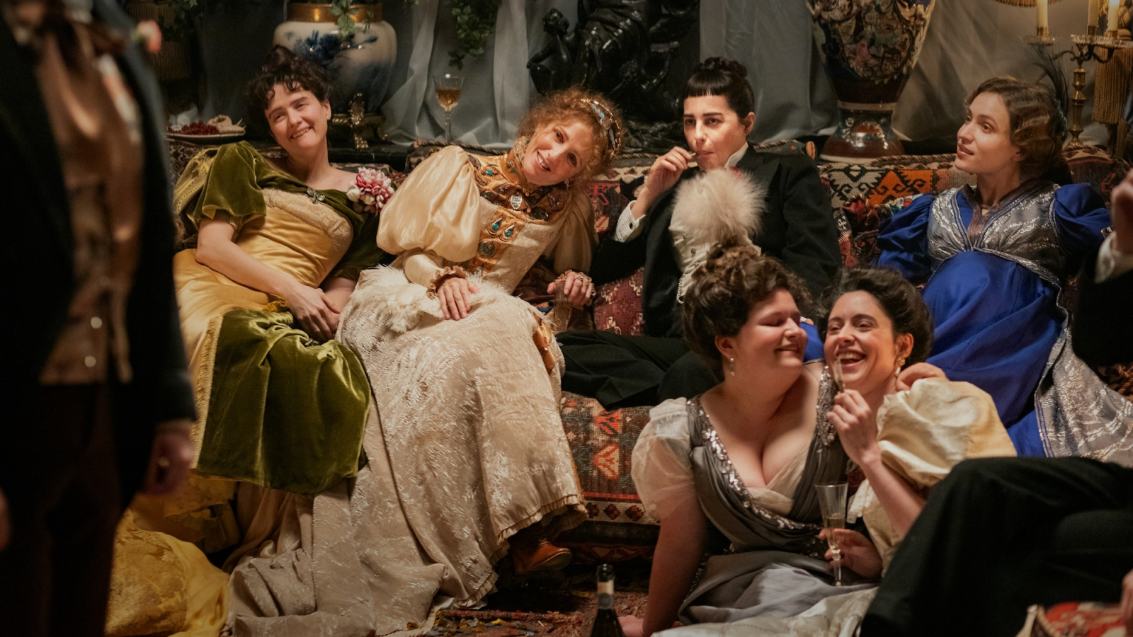 Kadr z filmu „Boska Sarah Bernhardt” ukazujący grupę kobiet w eleganckich strojach, bawiących się w towarzystwie.