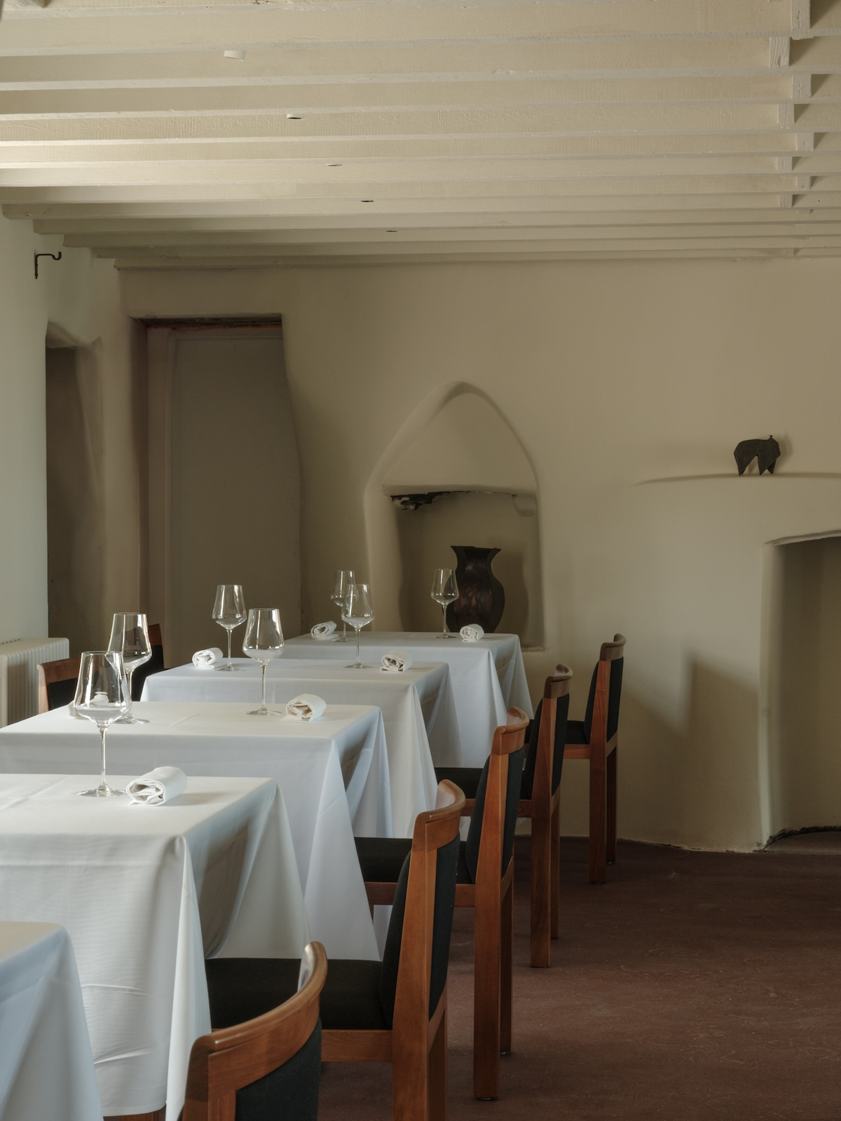 Wnętrze restauracji Osip z białymi stołami, filiżankami i eleganckimi kieliszkami. Jasne, minimalistyczne miejsce.