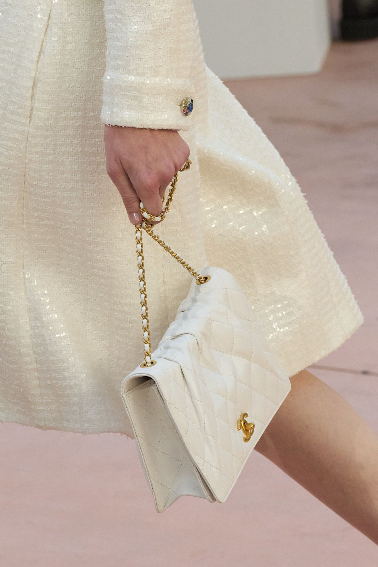 Biała torebka na pokazie Chanel na sezon wiosna-lato 2025, w eleganckim stylu.