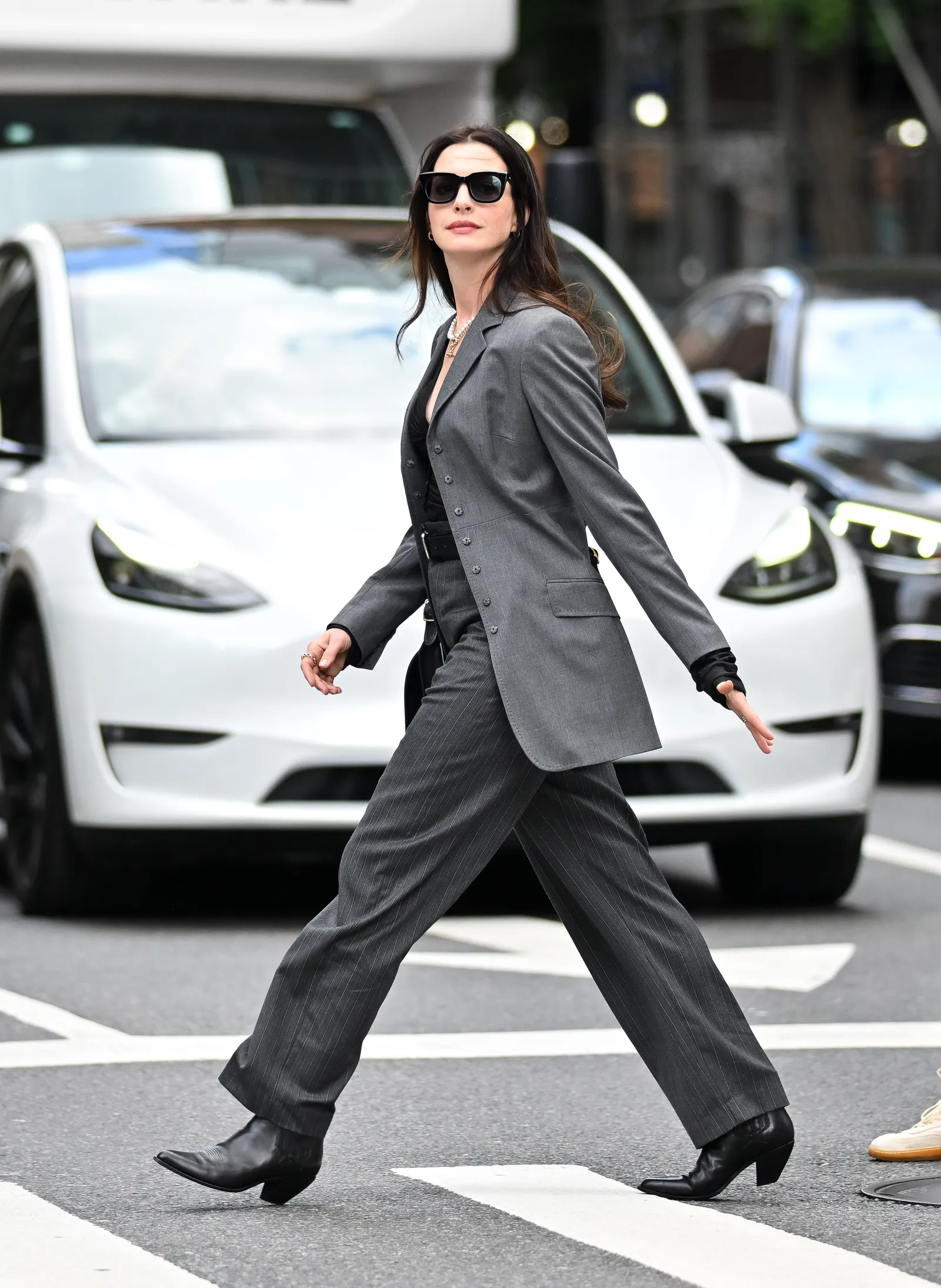 Anne Hathaway w czarnym garniturze w prążki i czarnych botkach. (Fot. Getty Images)