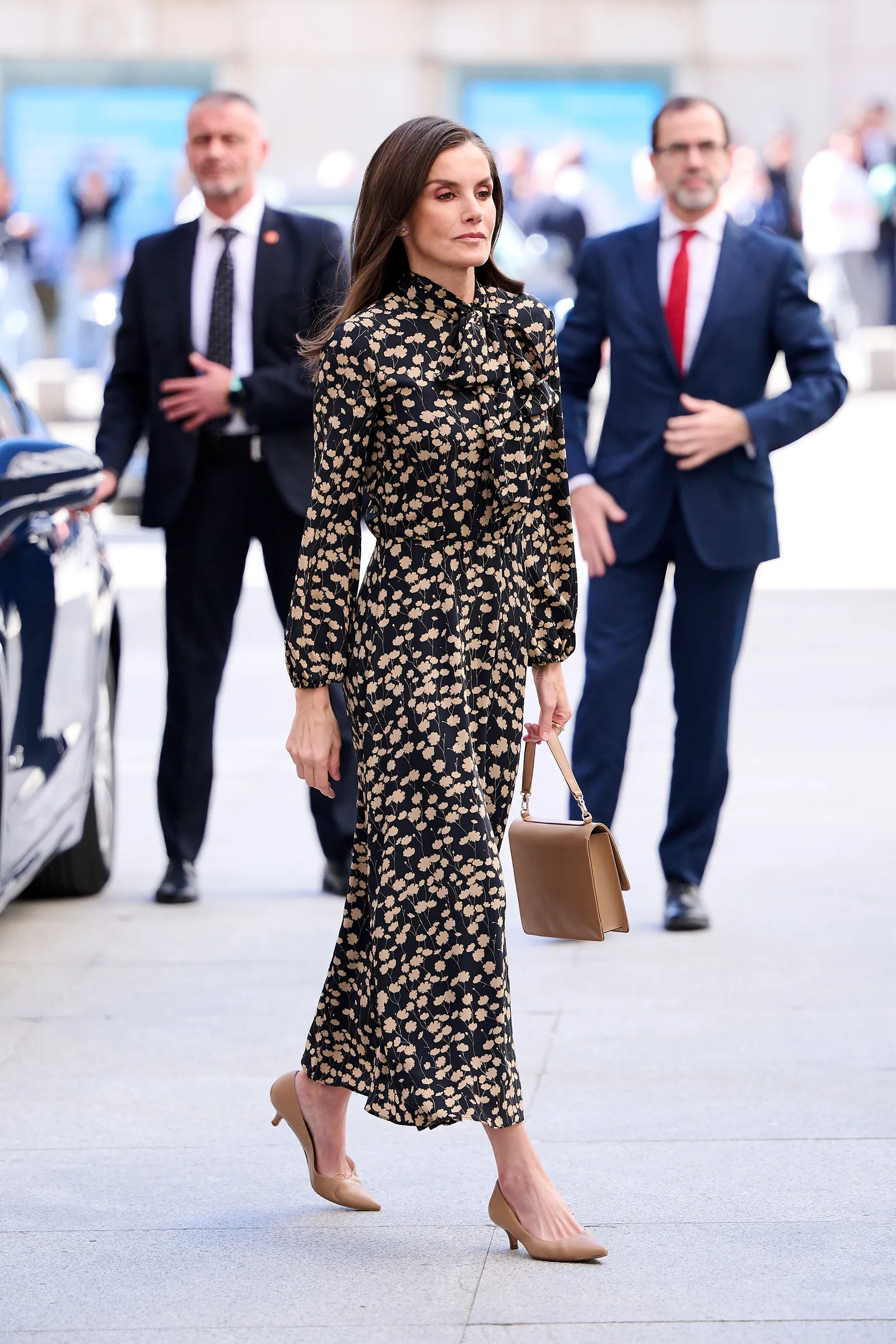 Królowa Letycja wygląda nieskazitelnie w sukience midi w kwiaty z elegancką kokardą i cielistymi butami na obcasie. Taka stylizacja dodaje sylwetce lekkości. / Fot. Getty Images