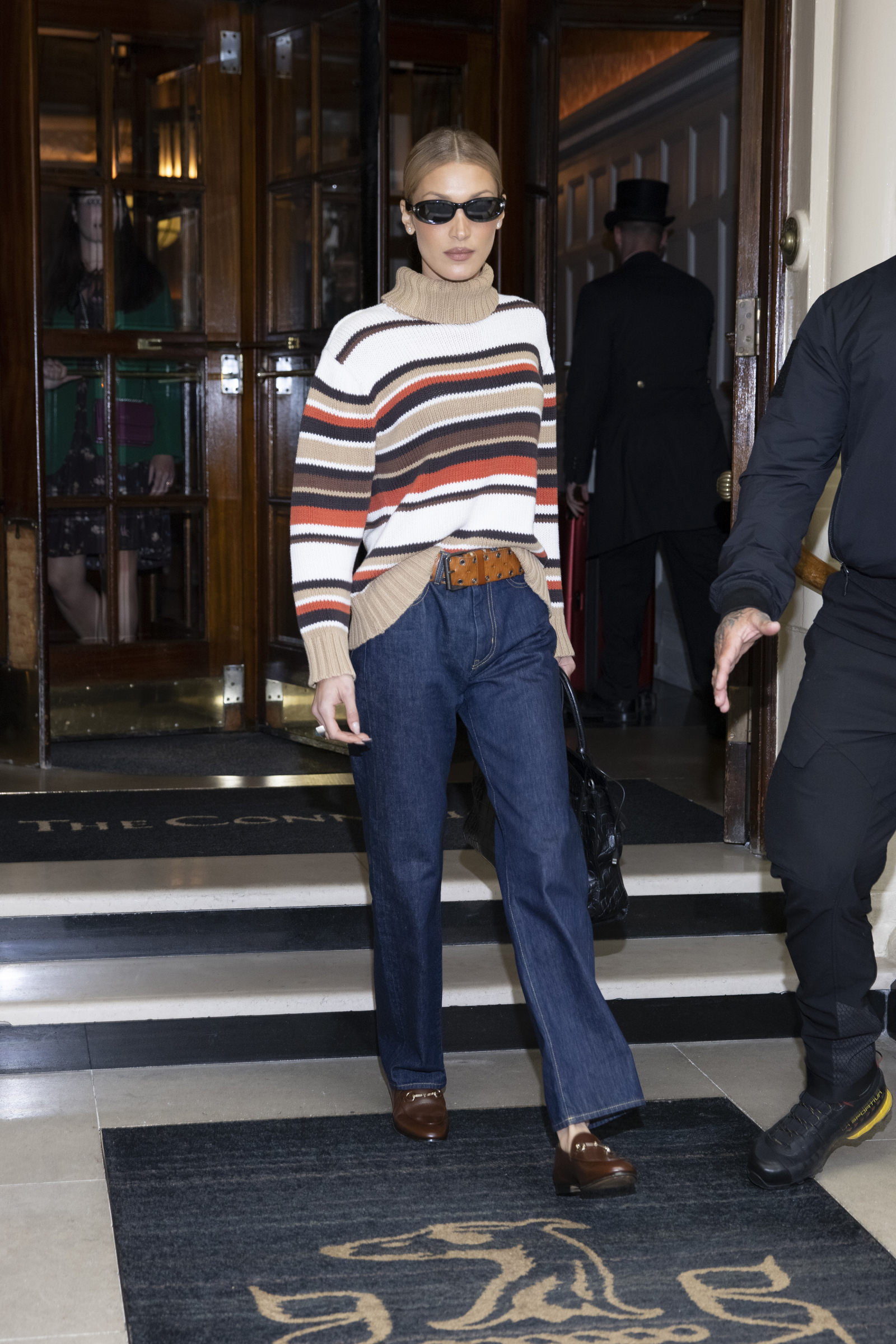 Bella Hadid łączy swoje brązowe mokasyny od Gucci z długimi spodniami wykonanymi z surowego jeansu (Fot. Ricky Vigil M/GC Images)