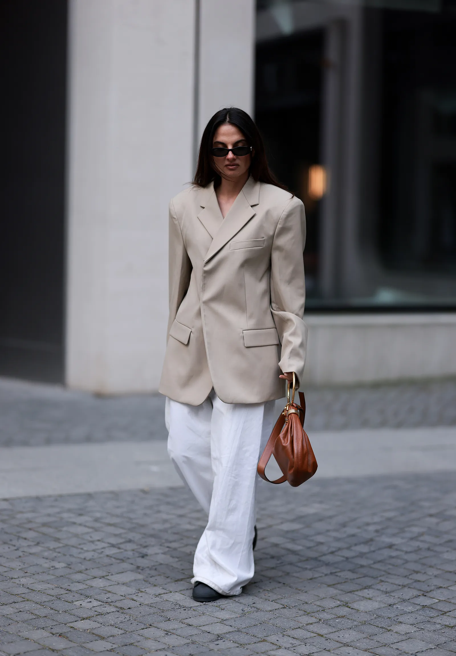 Latem 2025 miłośniczki street style’u stawiają na eleganckie czarne sneakersy zgodne z aktualnymi trendami. / Fot. Jeremy Moeller/Getty Images