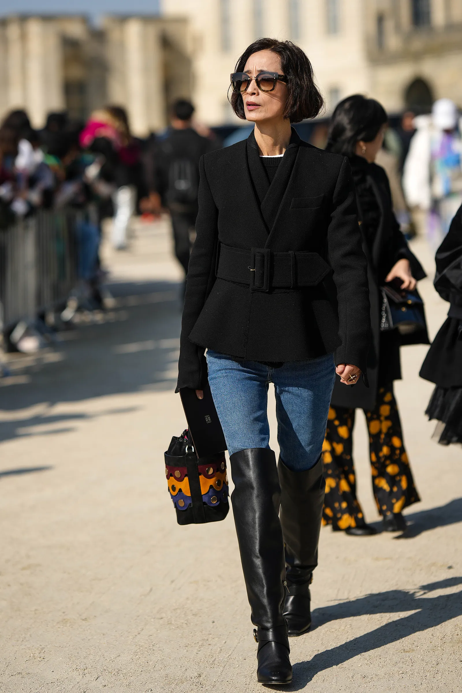 Street style proponuje wysokie kozaki do jeansowych spodni skinny jako trafny wybór dla kobiet 50+. (Fot. Edward Berthelot / Getty Images)