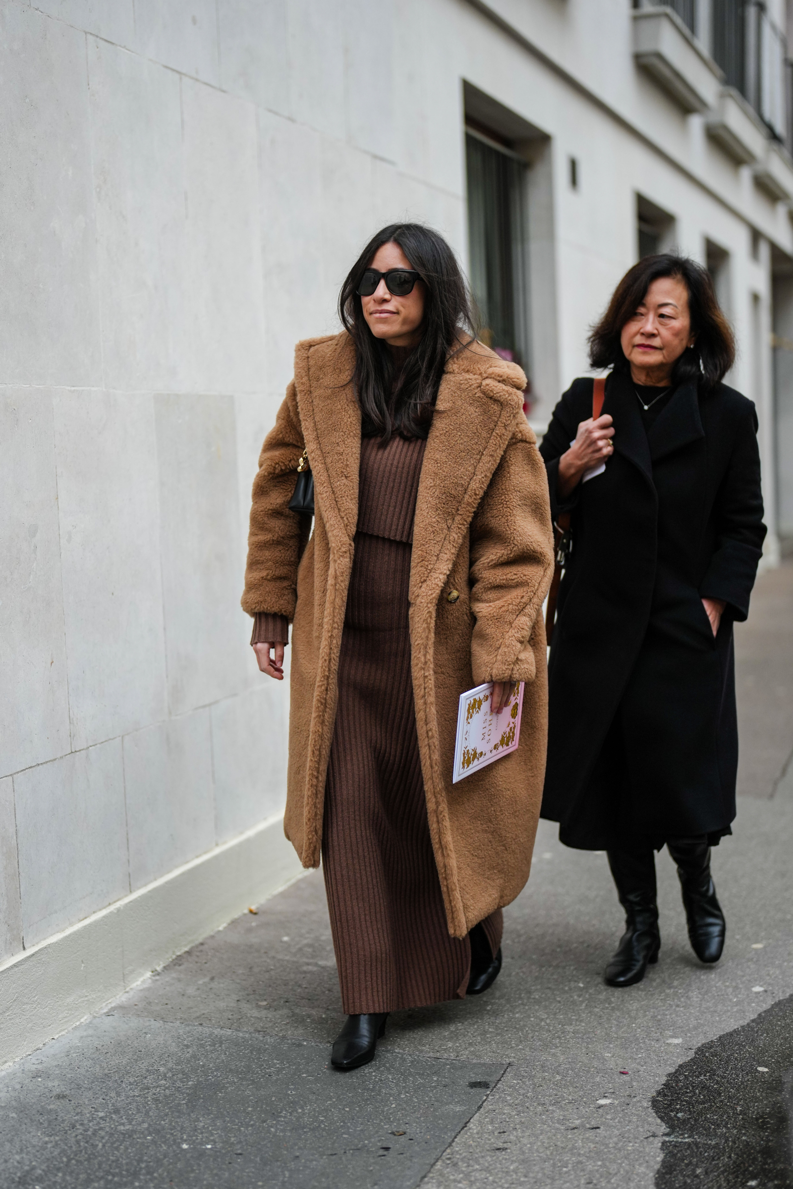 Brązowy płaszcz damski „teddy coat” sprawdzi się jako element nałożony na dzianinową sukienkę w tym samym kolorze (Fot. Edward Berthelot/Getty Images)