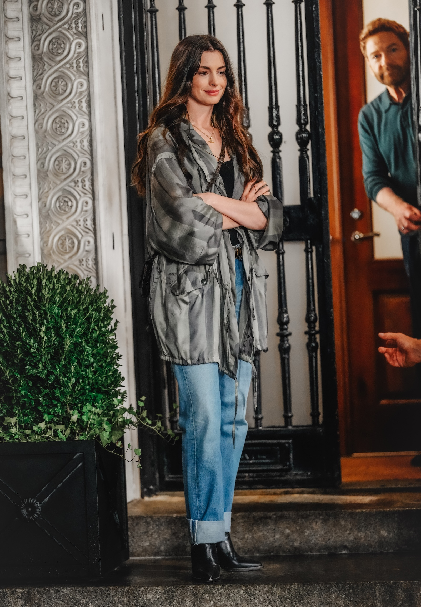 Anne Hathaway w parce, czarny top, niebieskie jeansy z podwiniętymi nogawkami, czarne botki na obcasie, na planie filmu „Diabeł ubiera się u Prady 2”.