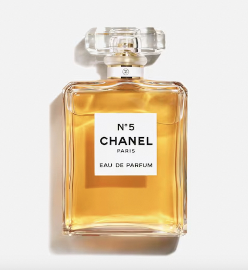 Flakon perfum Chanel N°5, kwadratowy z przezroczystą zakrętką, zawiera złocisty płyn.