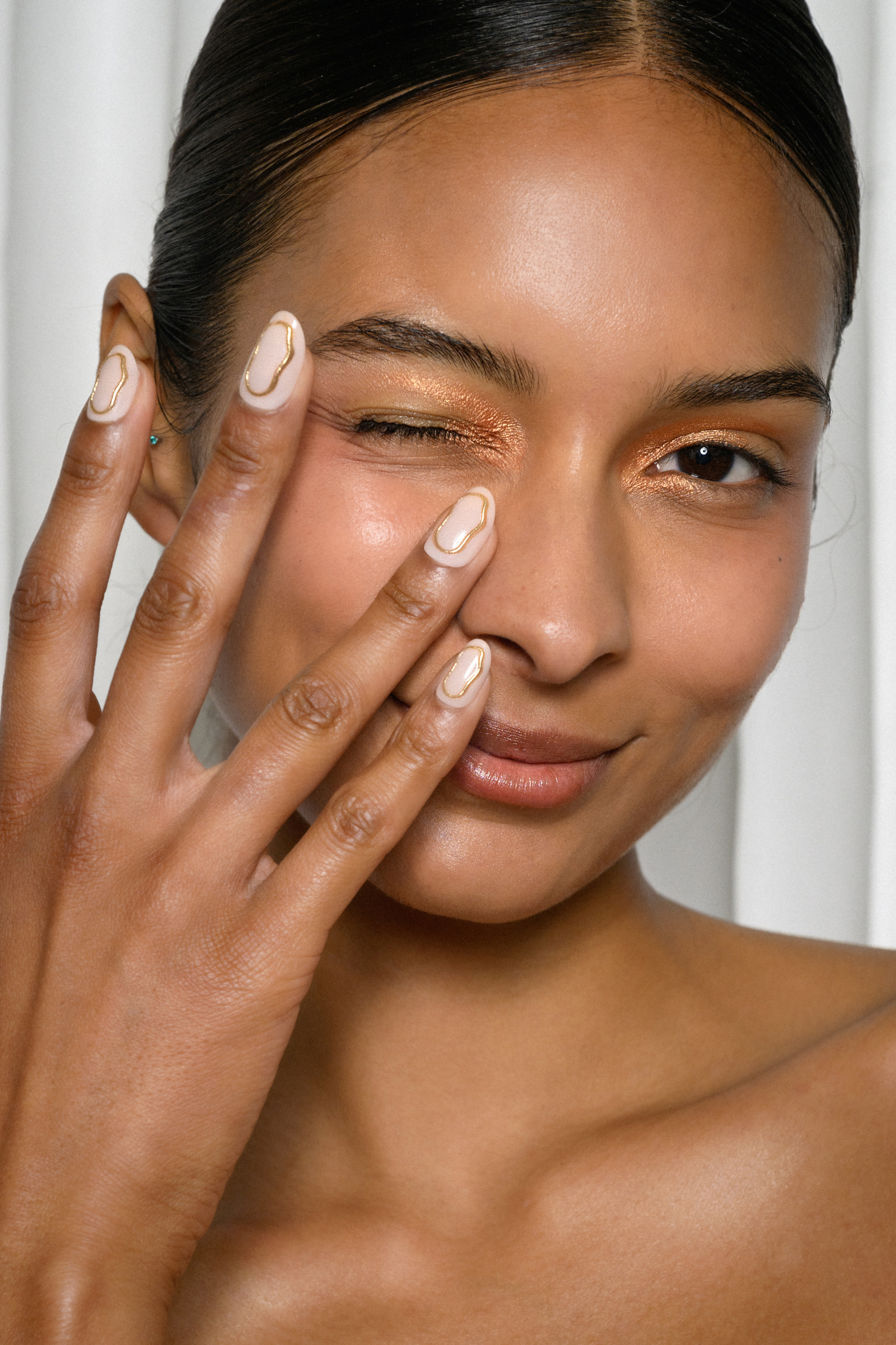 Delikatny zaręczynowy manicure w odcieniach nude z subtelnymi akcentami na paznokciach. Modelka w naturalnym makijażu.