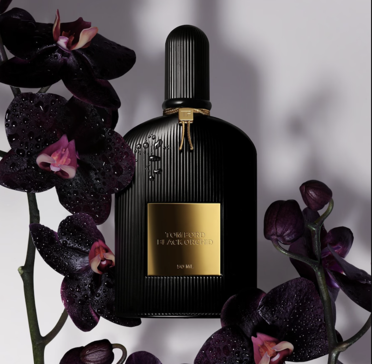 Butelka perfum Tom Ford Black Orchid, otoczona ciemnymi orchideami z kroplami wody. Elegancka i luksusowa prezentacja.