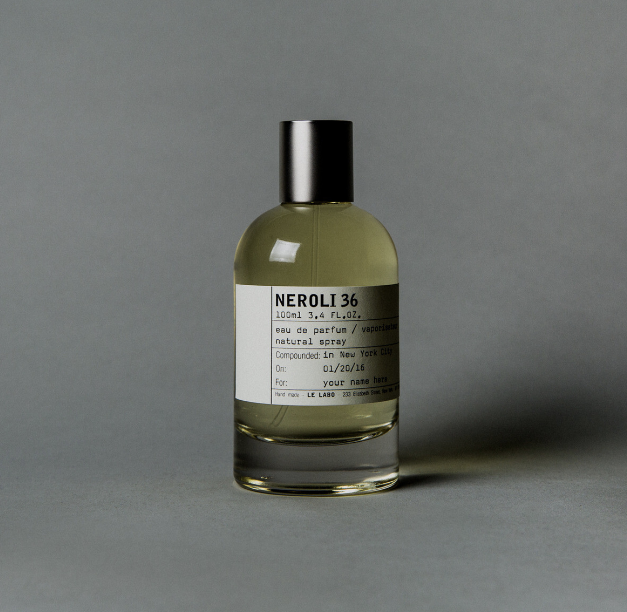 Perfumy pachnące jak dzień na plaży: Butelka perfum "Neroli 36" o pojemności 100 ml. Etykieta z informacjami o składzie i miejscu produkcji. Stonowane tło.