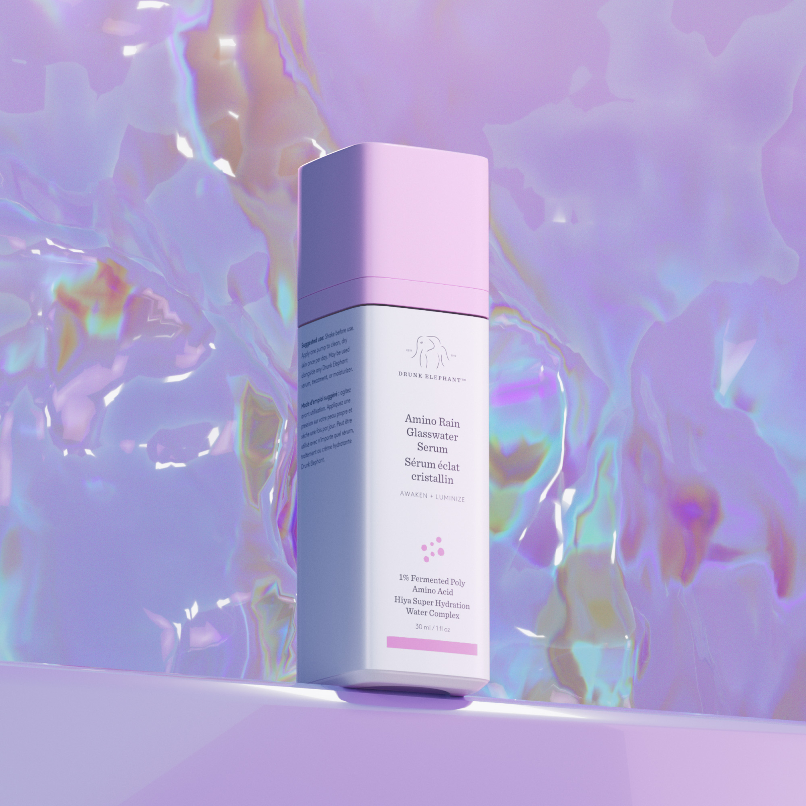 Serum do twarzy Amino Bain od Drunk Elephant w eleganckim opakowaniu z r&oacute;żowym wieczkiem, z holograficznym tłem.