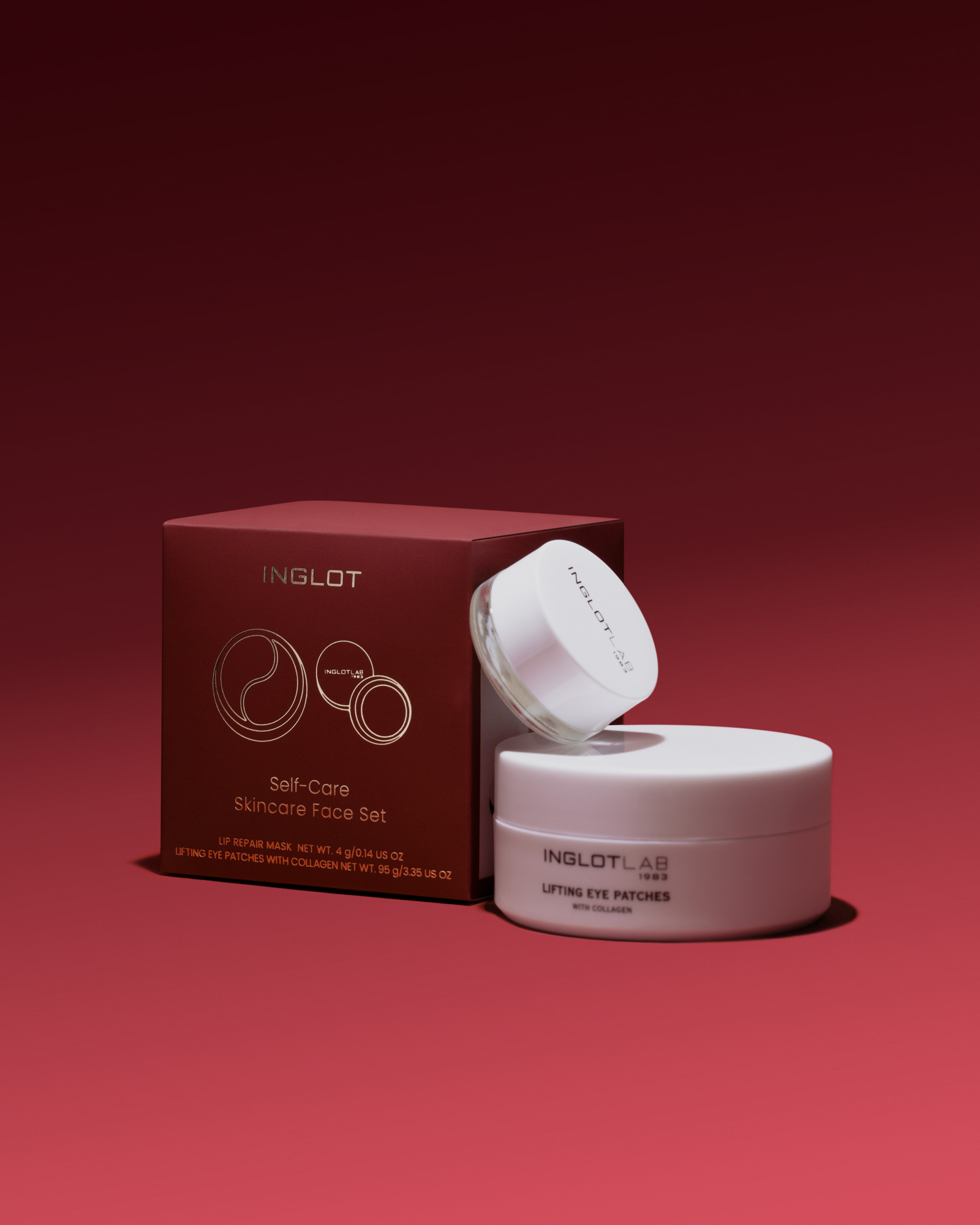 Zestaw pielęgnacyjny INGLOT zawiera krem do ust oraz liftingujące płatki pod oczy, umieszczone na tle w odcieniach czerwieni.