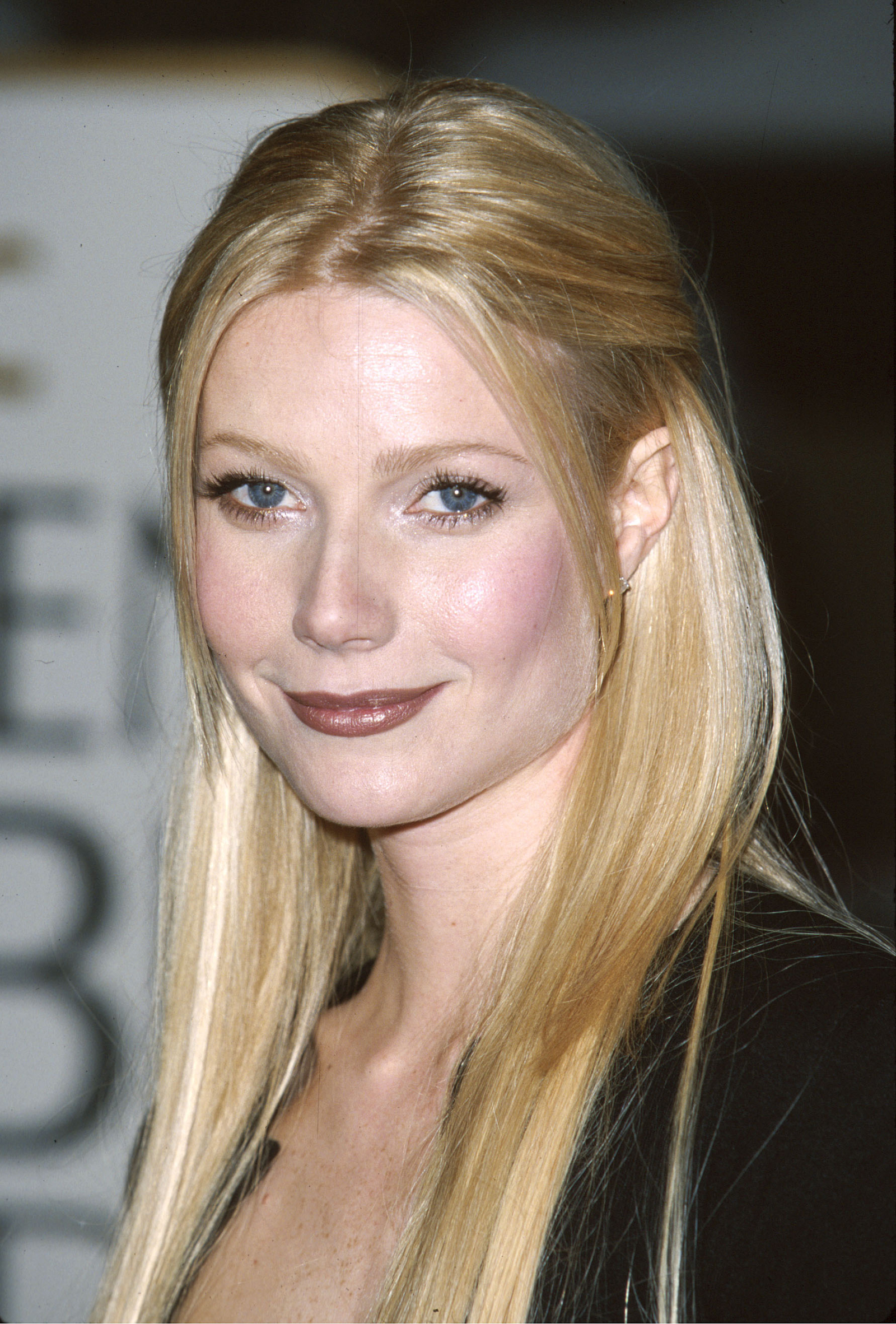 Gwyneth Paltrow z brązowymi ustami, lata 90. Elegancka fryzura i delikatny makijaż podkreślający jej urodę.