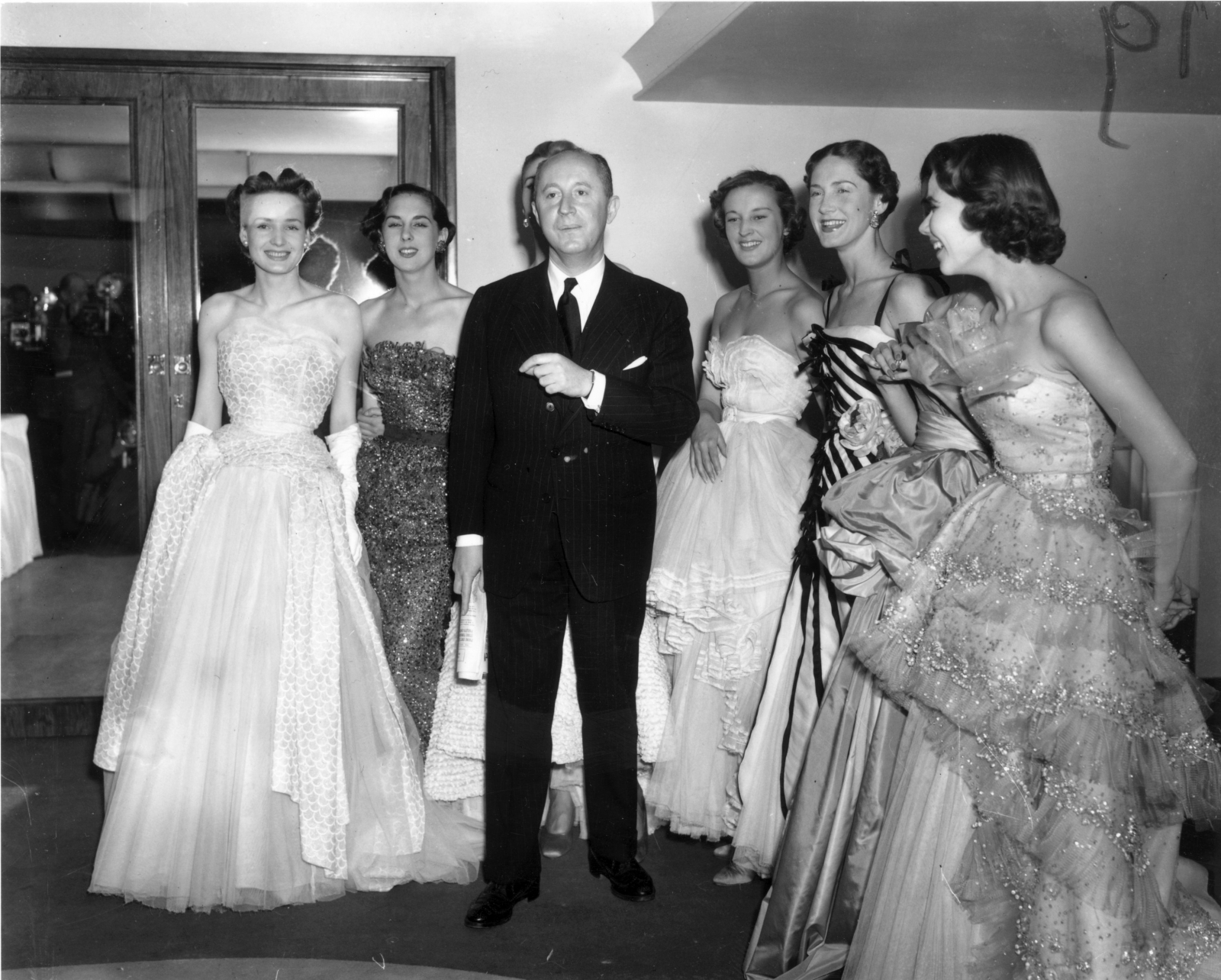 Projektant mody Christian Dior, twórca stylu „New Look” i „A-Line”, z sześcioma modelkami po pokazie mody w hotelu Savoy w Londynie 25 kwietnia 1950 roku (Fot. Fred Ramage/Keystone/Getty Images)