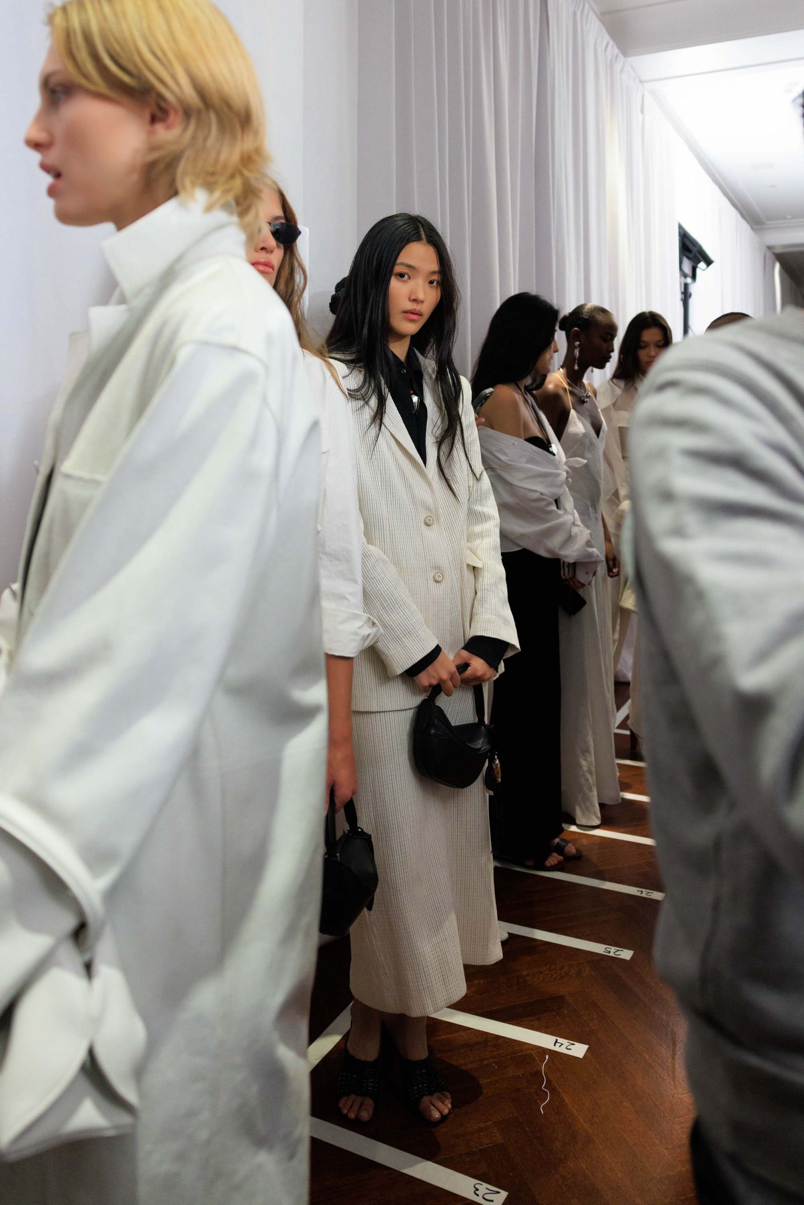 Modele za kulisami pokazu Ralph Lauren na wiosnę 2026, w eleganckich stylizacjach w odcieniach bieli i czerni.
