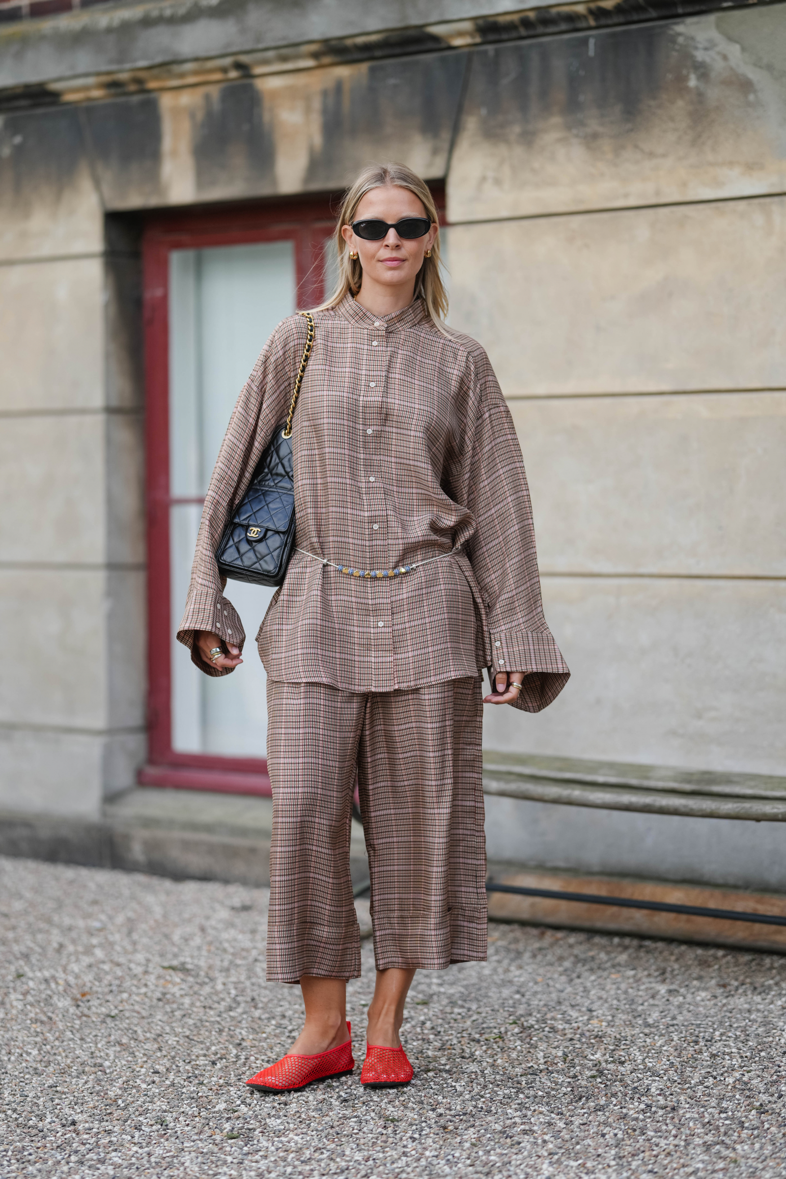 Hollie Mercedes Peters do brązowego setu dodała czerwone siateczkowe baleriny i pikowaną torebkę Chanel (Fot. Edward Berthelot/Getty Images)