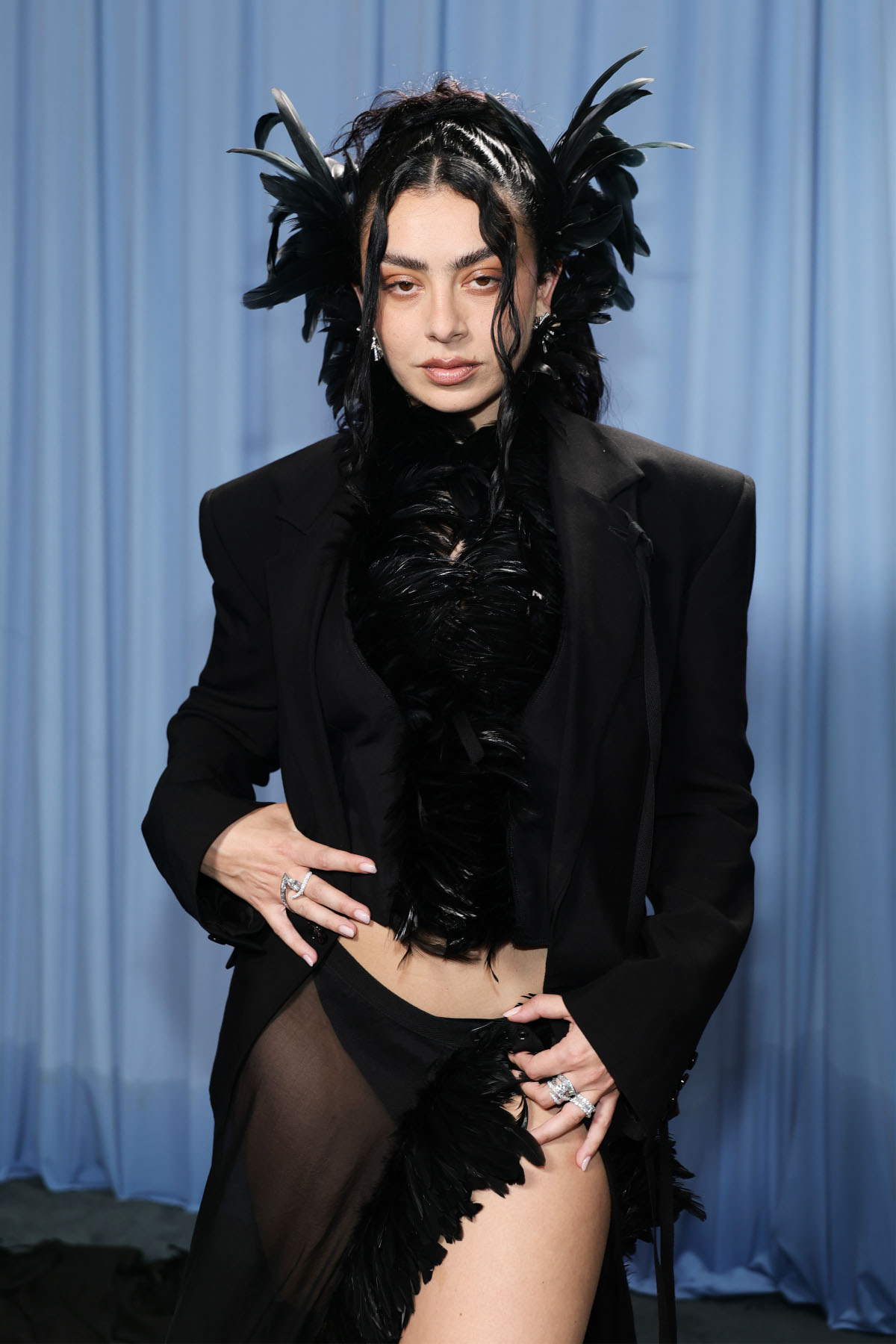 Charli XCX w awangardowej kreacji z piórami na Met Gala 2025, prezentując odważny styl i oryginalność.