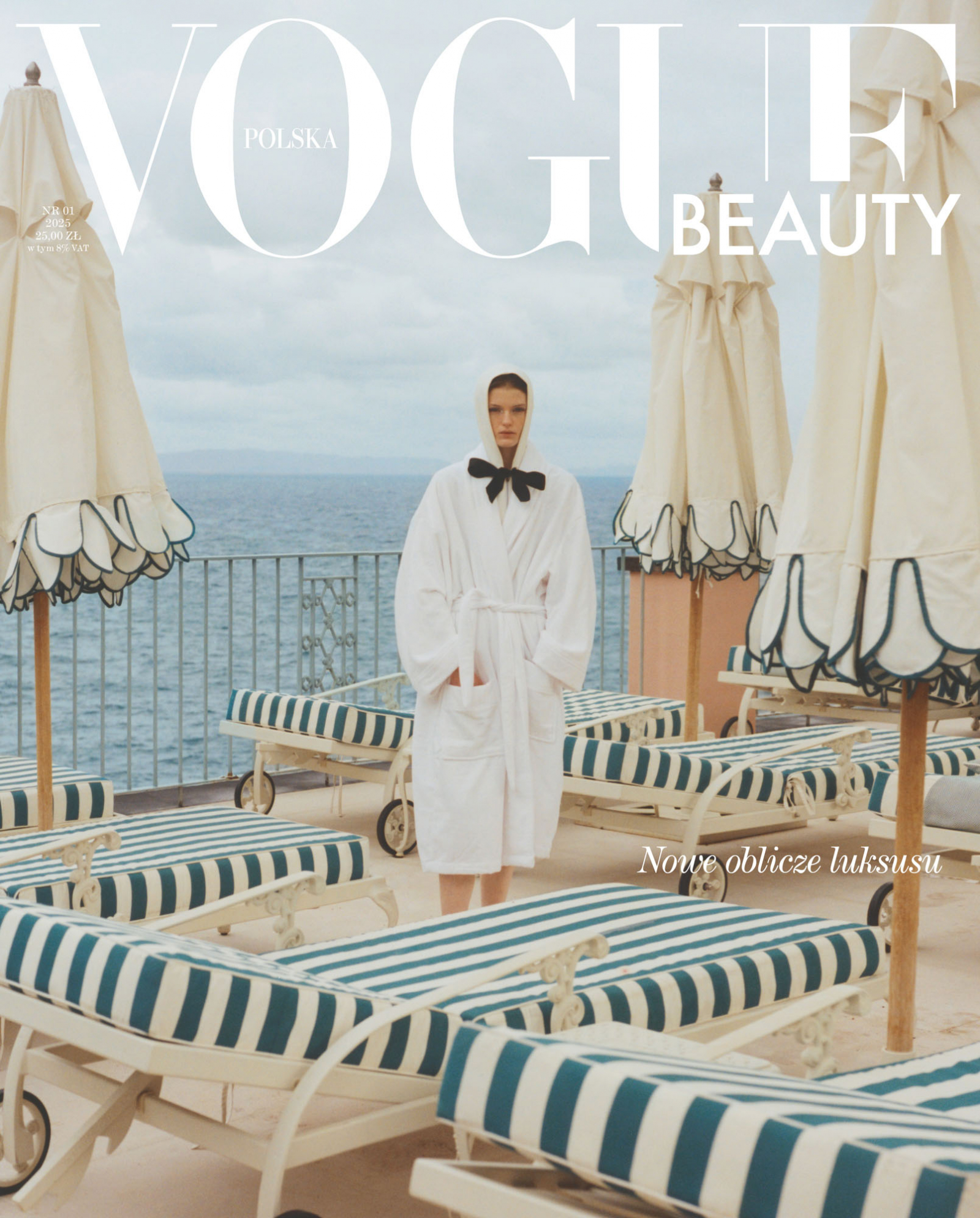 Modelka w szlafroku z kokardą na tle leżaków i parasoli przy morzu, na okładce "Vogue Polska Beauty".