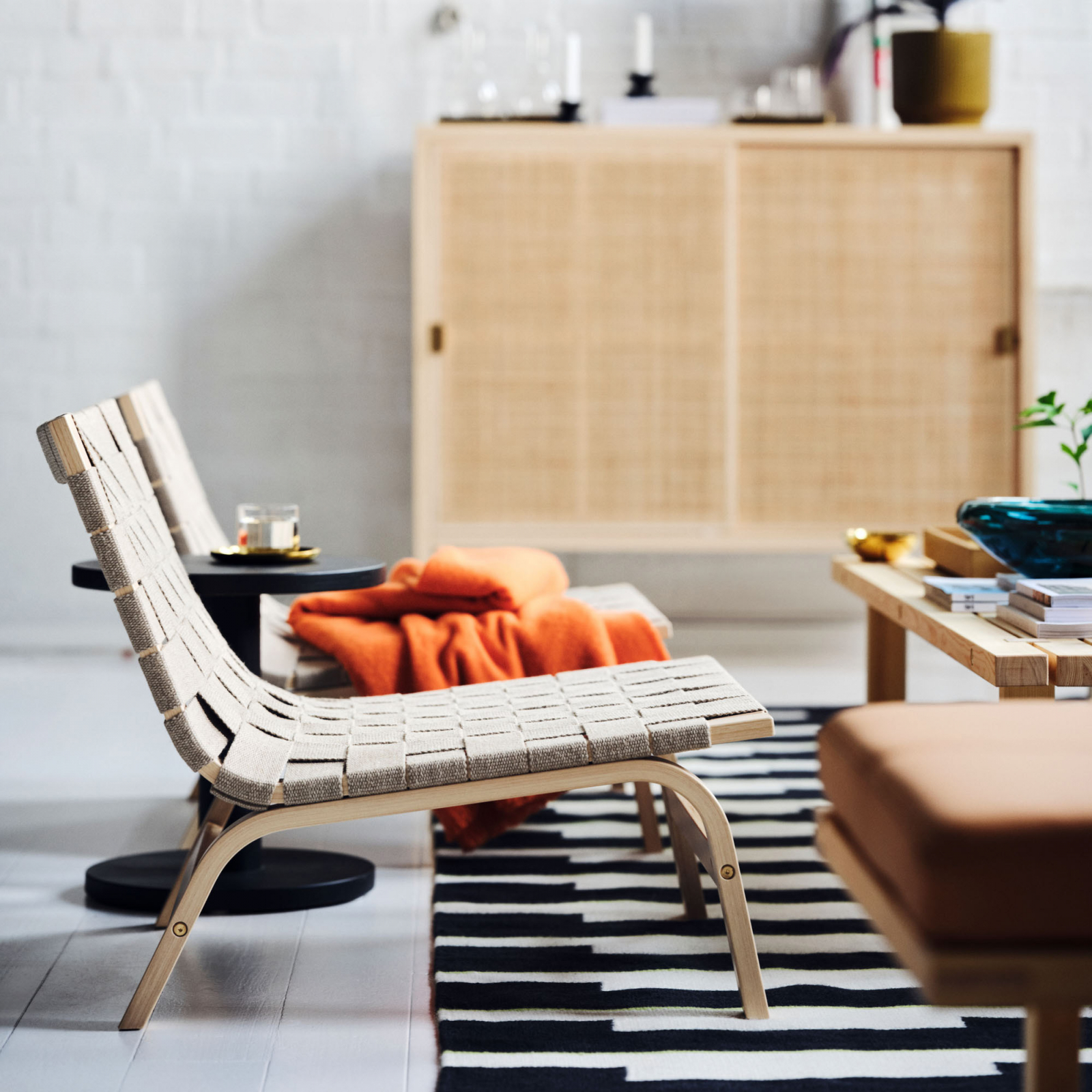 Elegancki kącik wypoczynkowy z meblami Ikea, w tym stylowymi fotelami i stół, wykończony ciepłymi akcentami.
