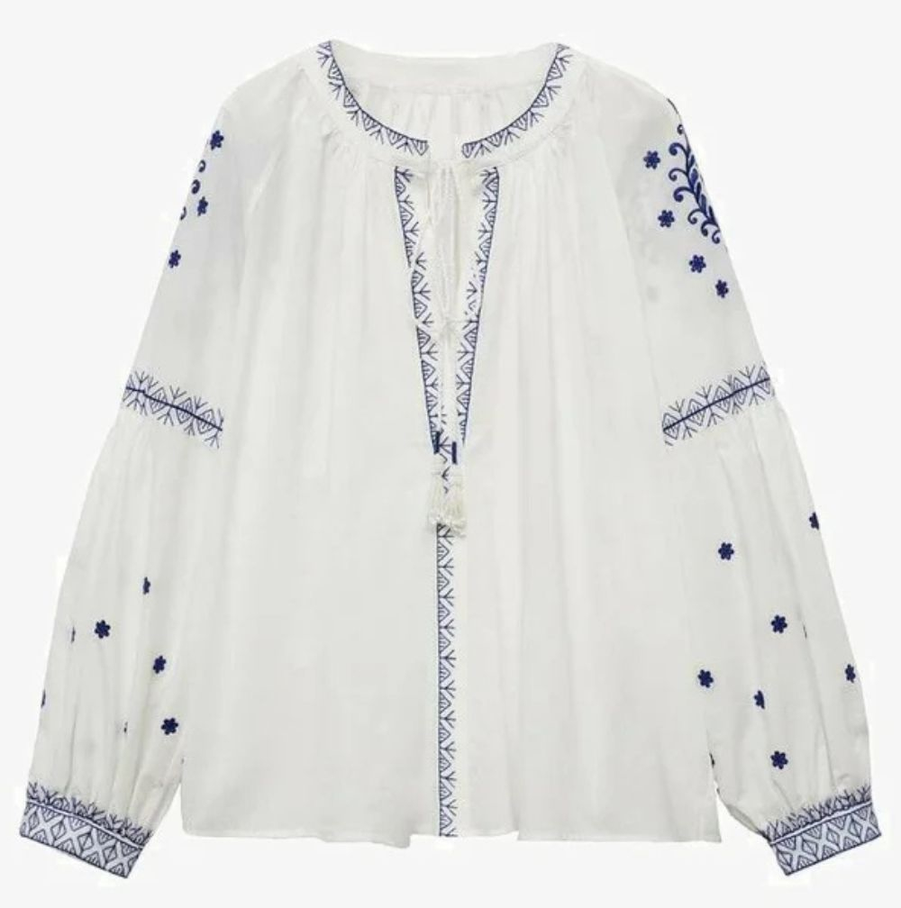 Boho koszula damska w stylu Francuzek, biała z niebieskimi haftami i długimi rękawami, o luźnym kroju.