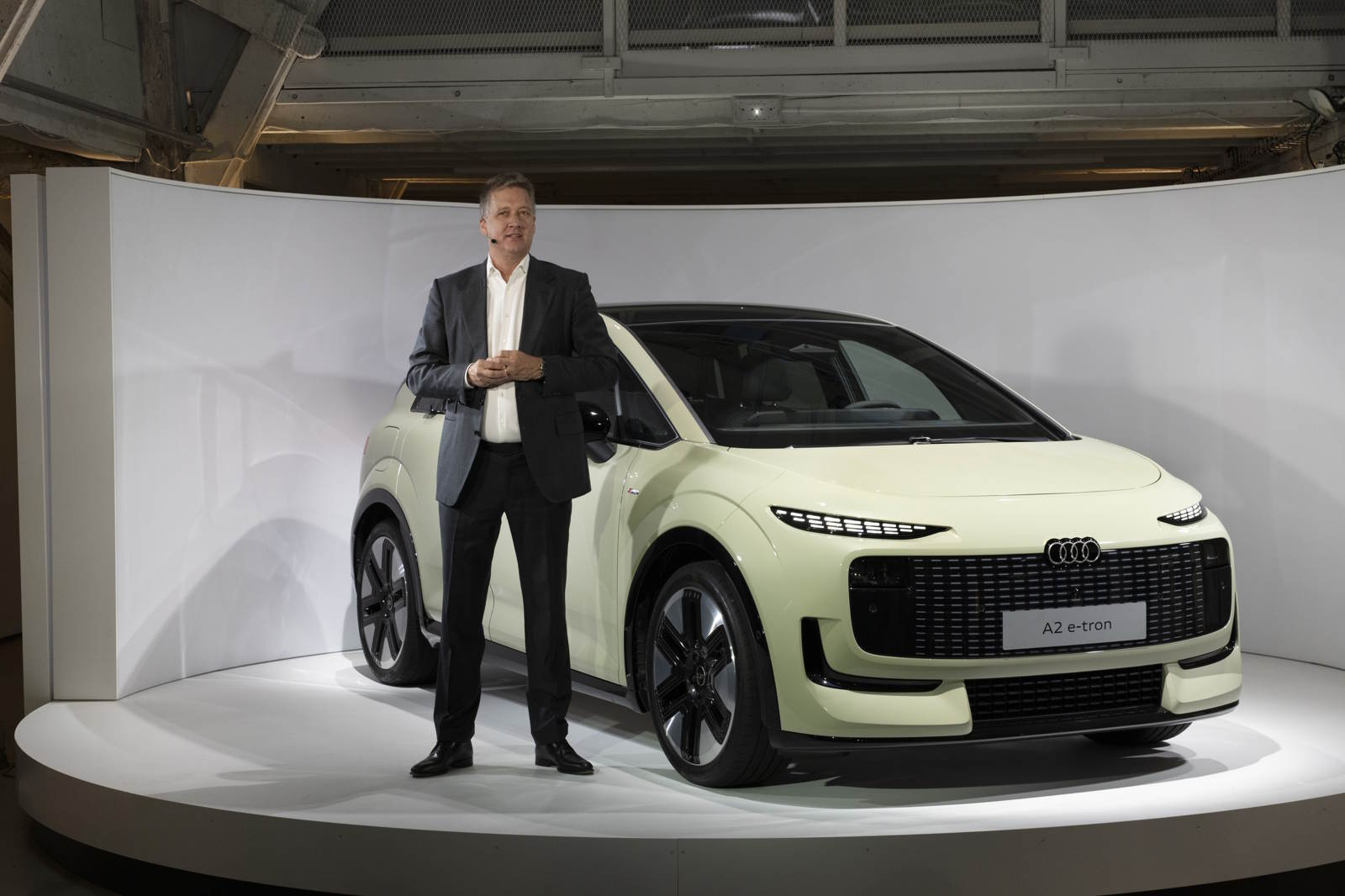 Prezentacja nowego modelu Audi A2 e-tron, obok samochodu stoi CEO Audi, Gernot D&ouml;llner w eleganckim garniturze.