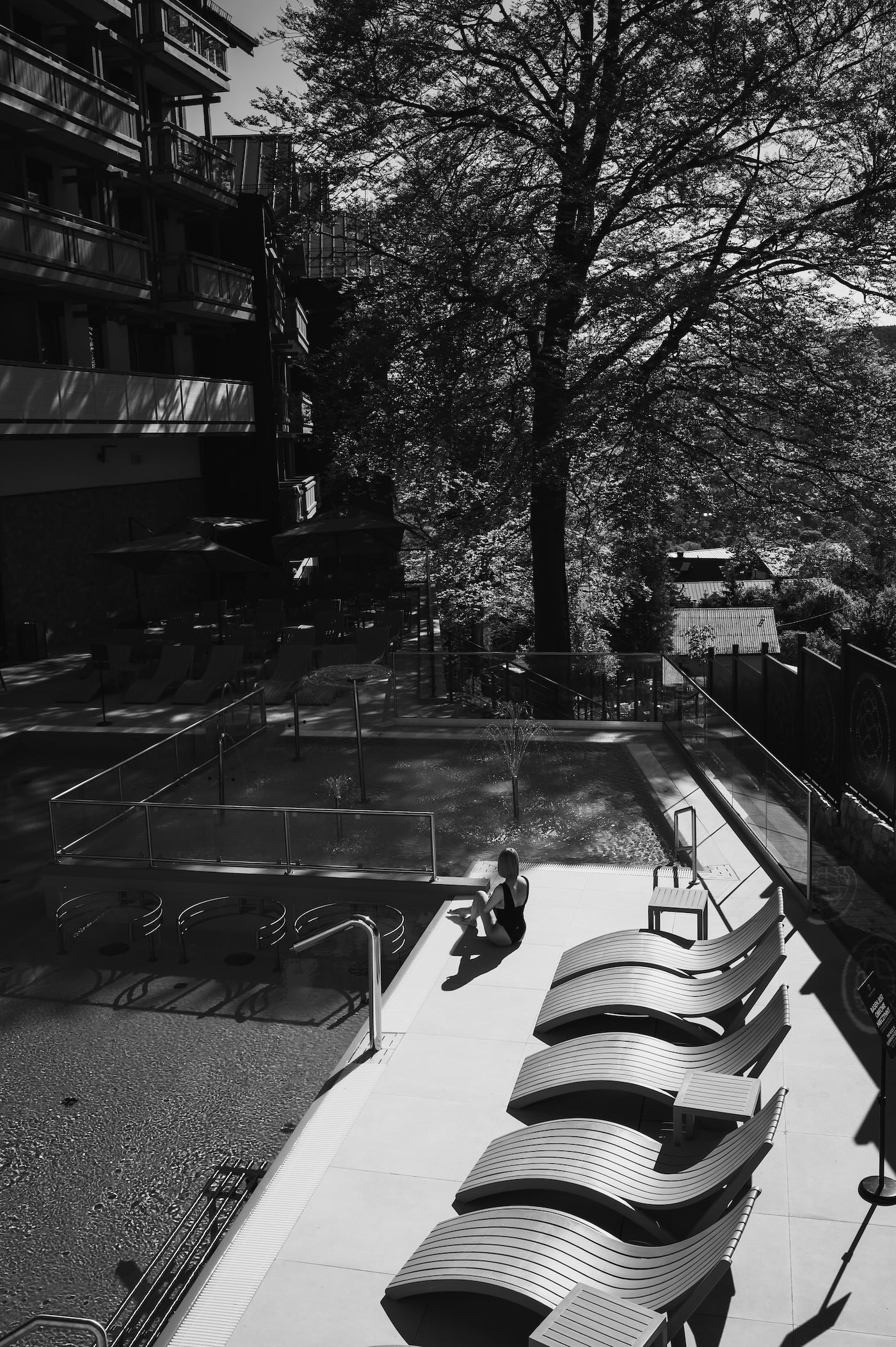 Luksusowe wnętrze ze strefą wellness w Forest Park Resort & Spa, z basenem, roślinnością i leżakami.