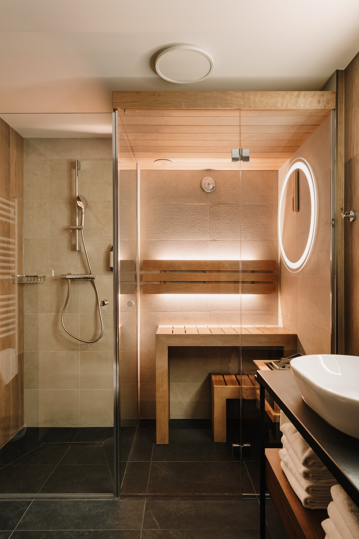 Nowoczesna łazienka w Forest Park Resort & Spa z sauną, prysznicem i drewnianymi elementami.