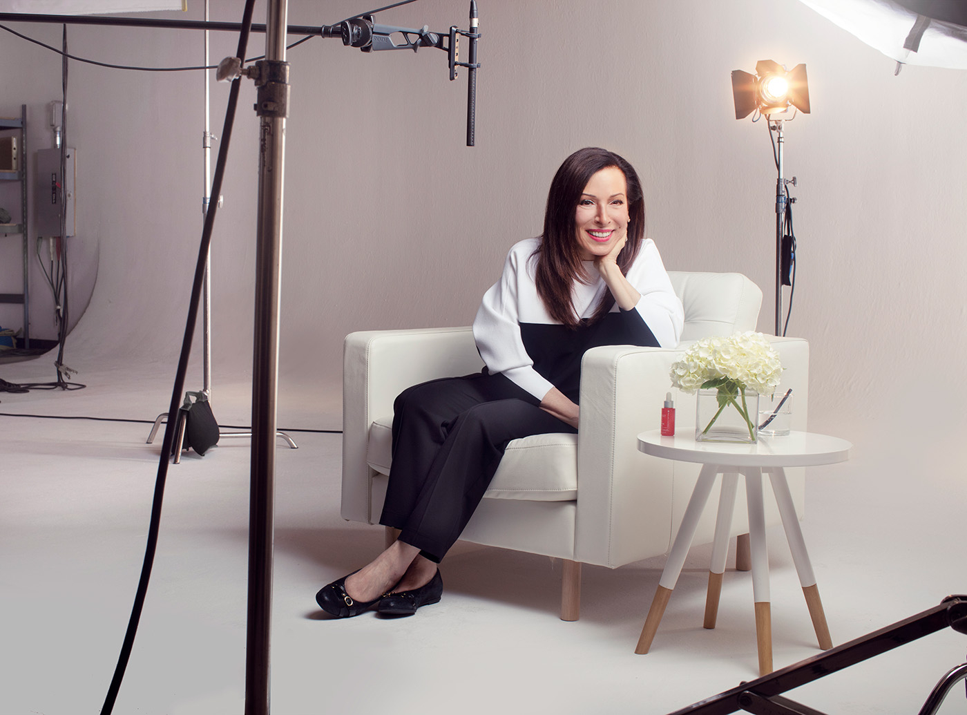 Paula Begoun, twórczyni marki Paula’s Choice, pozuje do zdjęcia w studio na tle tła, wśród lamp.