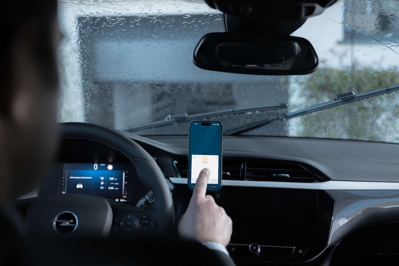 Mężczyzna w samochodzie używający aplikacji na smartfonie.