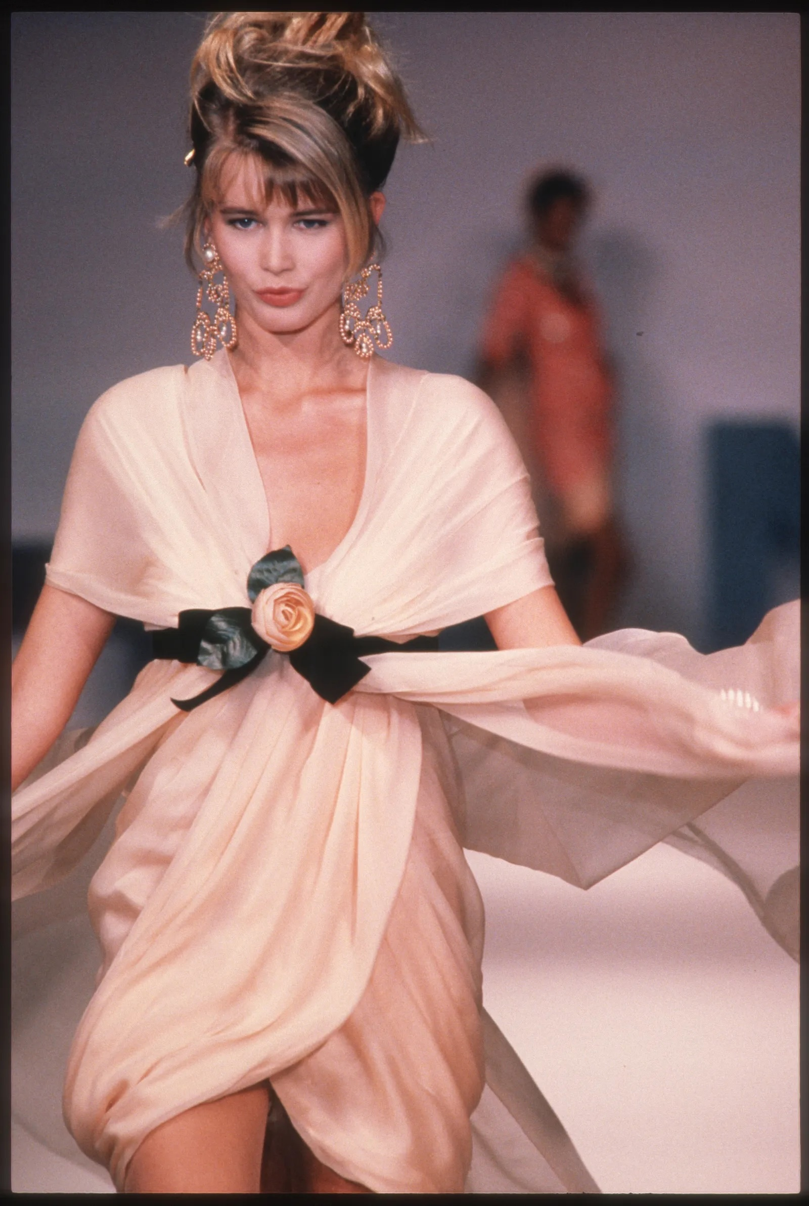 Claudia Schiffer na pokazie Chanel na sezon wiosna-lato 1990, w zwiewnej sukni z różyczką.