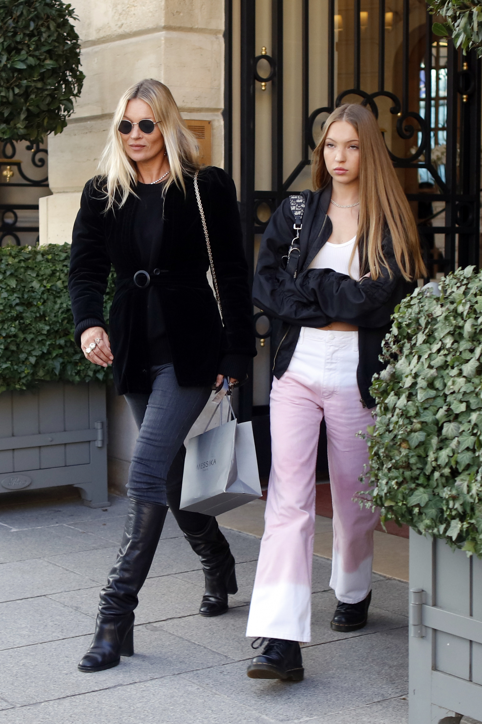 Kate Moss i Lila Moss w ciemnych skinny jeans oraz czarnych kozakach na obcasie, spacerują na ulicy.