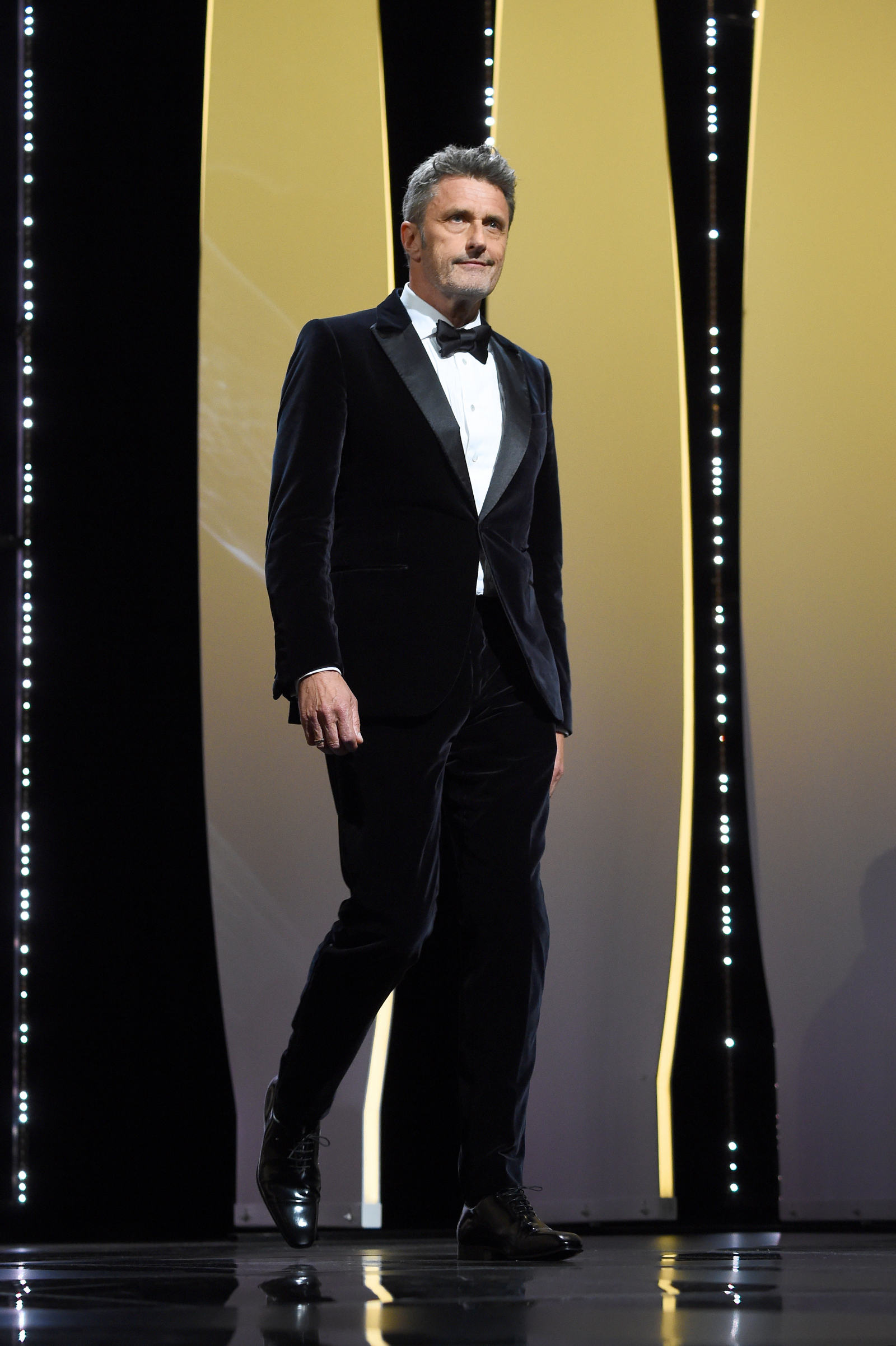 Reżyser Paweł Pawlikowski na festiwalu filmowym w Cannes w 2019 roku, ubrany w elegancki garnitur.