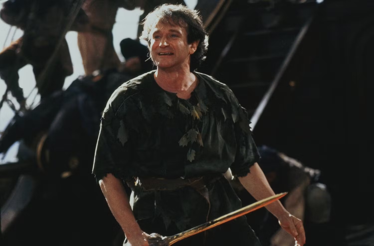 Robin Williams w filmie „Hook” jako Piotruś Pan, w stroju z elementami kostiumu pirackiego.
