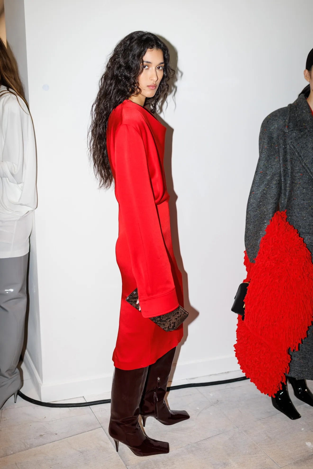 Modelka w burgundowych kozaki na szpilce prezentuje strój na pokazie Stelli McCartney na sezon jesień-zima 2025.