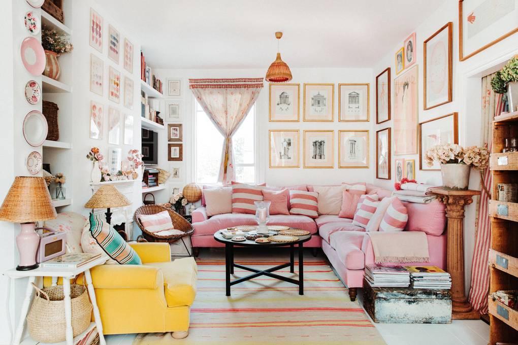 Zarówno różowa sofa, jak i żółty fotel pokryte są welurową tkaniną kupioną w Designers Guild. Dywan w paski pochodzi z firmy rodziców specjalizującej się w meblach ogrodowych, Odd Limited. (Fot. Owen Gale dla House&Garden)