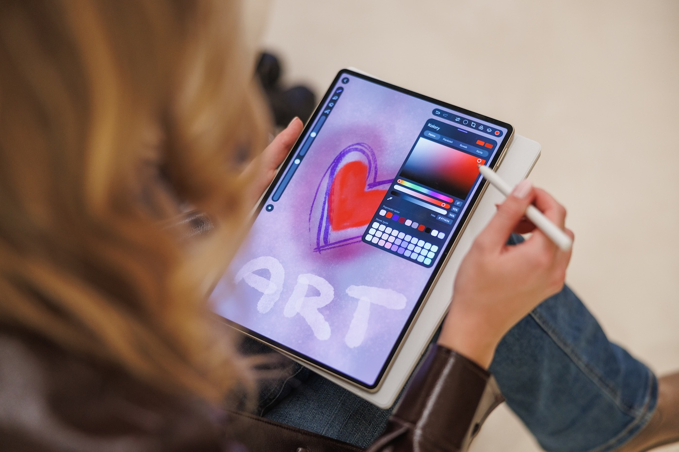 Tablet Huawei MatePad Pro z rysikiem, na którym użytkowniczka tworzy grafikę z napisem "ART" i sercem w tle.