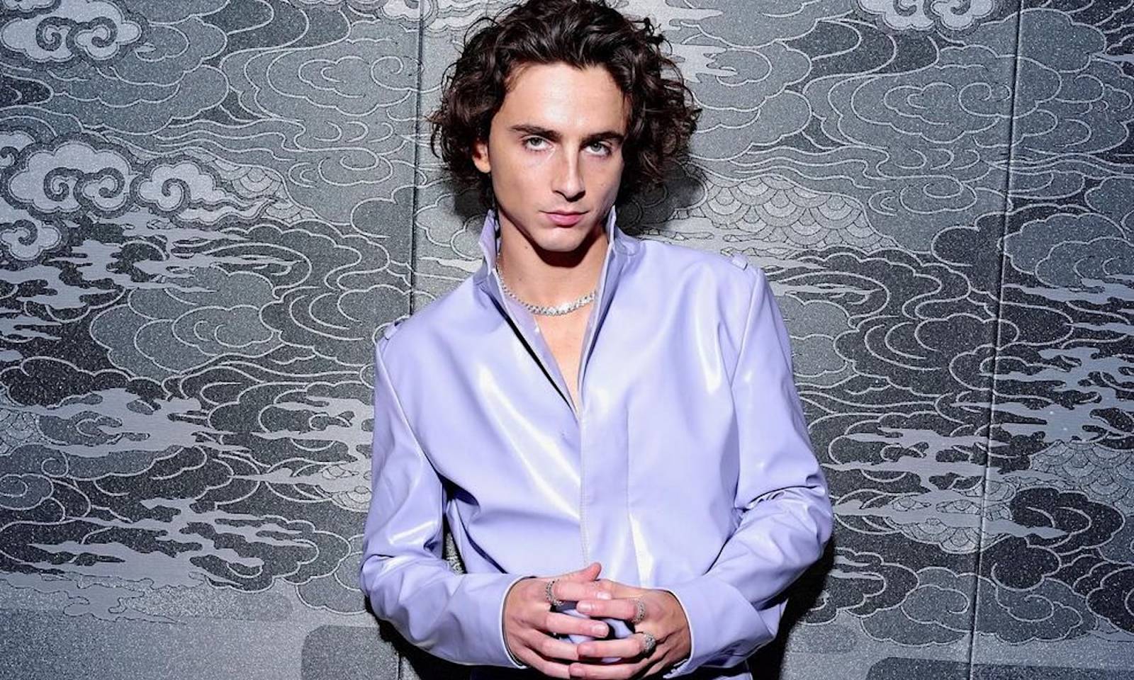 Timothée Chalamet uwielbia modowe eksperymenty na czerwonym dywanie i poza nim. Podczas wizyty w Tokio nosił lawendowy komplet z lateksu od Prady.