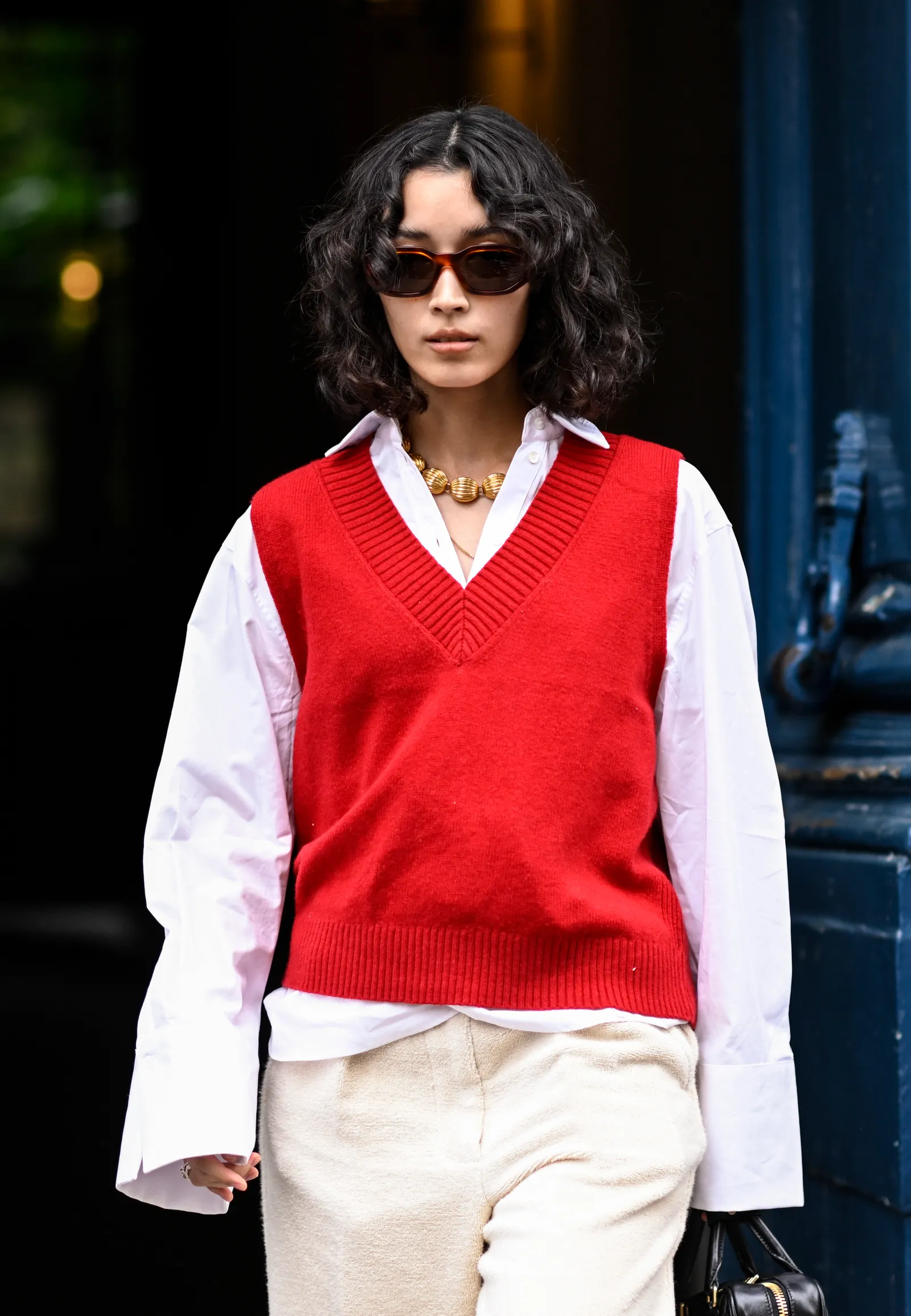 Street style: czerwona ciepła kamizelka damska z białą koszulą. (Fot. Daniel Zuchnik/Getty Images)