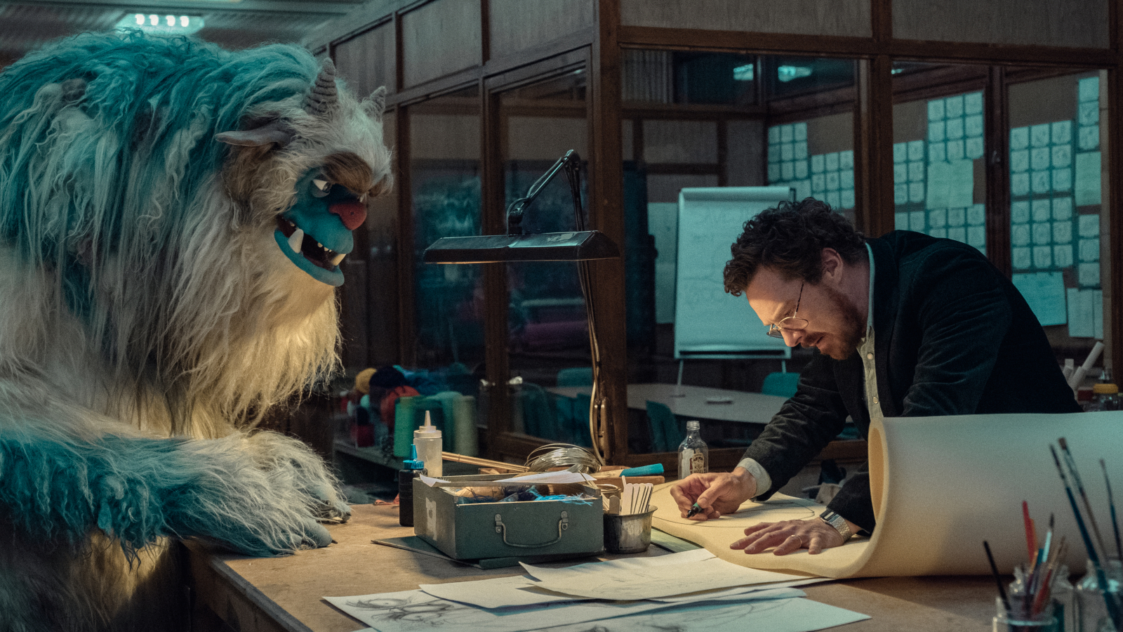 Benedict Cumberbatch w serialu Netflix „Eric” razem z dużym, futrzastym stworem w kreatywnym biurze.