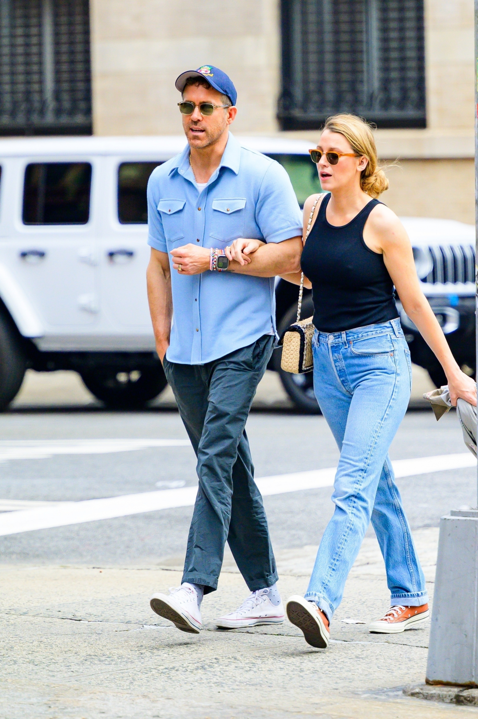 Para spaceruje po mieście. Blake Lively ma na sobie jeansy z wysokim stanem i kolorowe trampki, trzyma mężczyznę za rękę.