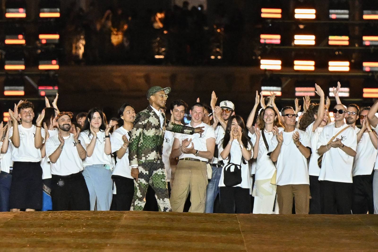 Pharrell Williams razem z rzemieślnikami pracującymi przy jego debiutanskiej kolekcji Louis Vuitton ( Fot. Corbis/Corbis via Getty Images)