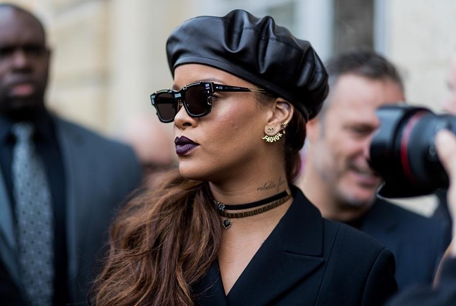 Piosenkarka Rihanna w czarnych okularach i skórzanym berecie przed pokazem Diora w Paryżu w 2017 roku.