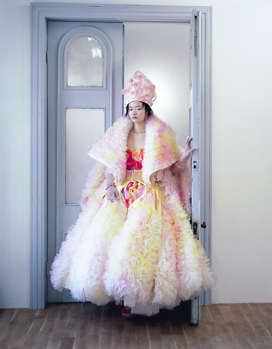 Modelka Tsugumi Nakamura w płaszczu Maison Margiela Artisanal oraz sukience marki przekształconej przez Tomo Koizumiego. Włosy i makijaż: Haruka. Stylizacja: Shotaro Yamaguchi (Fot. Takashi Homma/Vogue, wrzesień 2021)