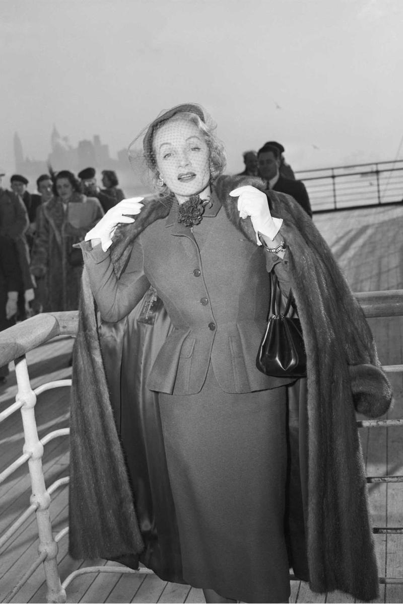 Marlene Dietrich wearing a day suit by Christian Dior onboard the Queen Elizabeth arriving in New York, 21 December 1950 (Photo: Getty Images)