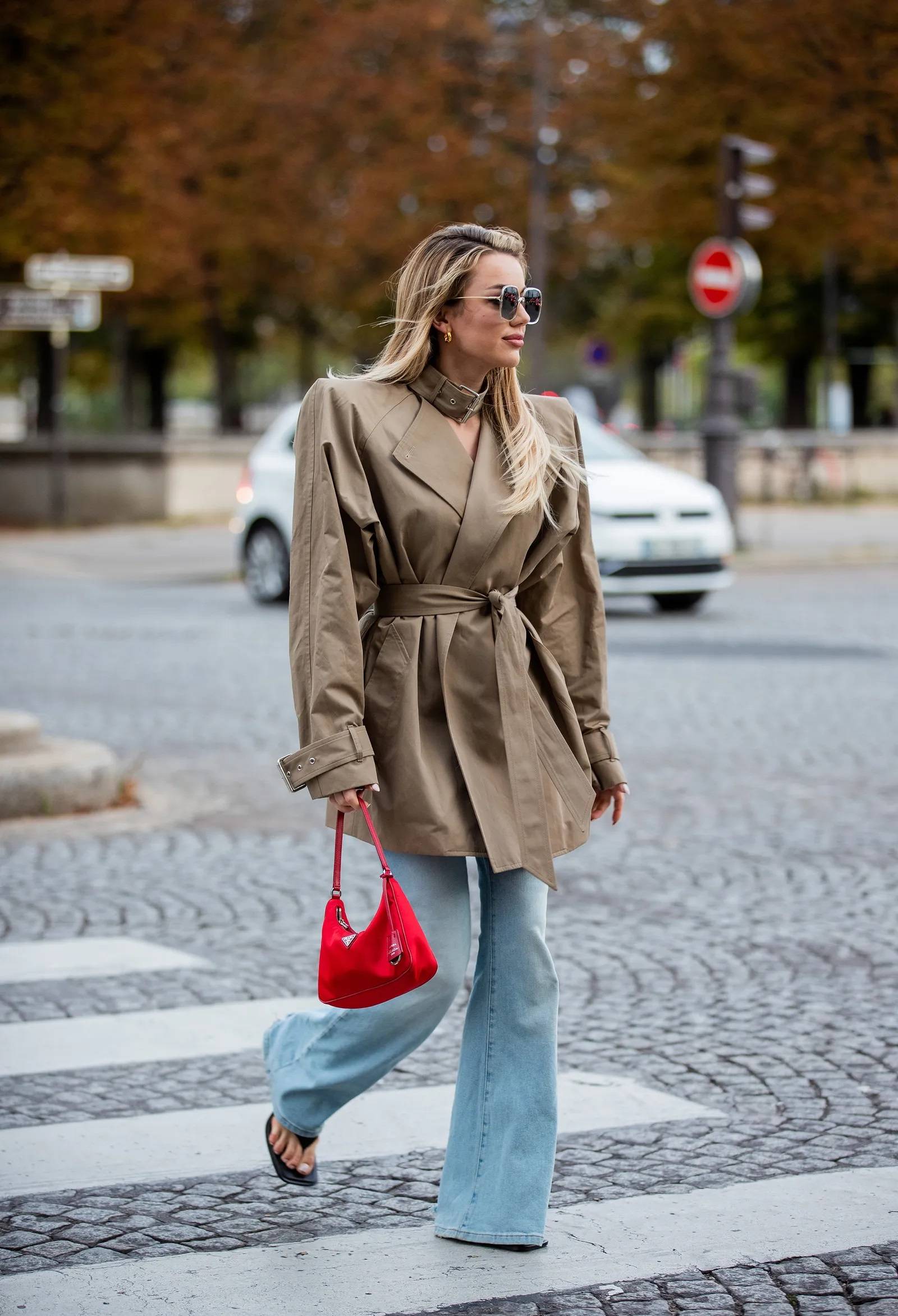 Moda na damskie spodnie dzwony wróciła w sezonie wiosna-lato 2024. Street style stawia na dopełnienie tych jeansowych spodni japonkami (Fot. Christian Vierig/Getty Images)